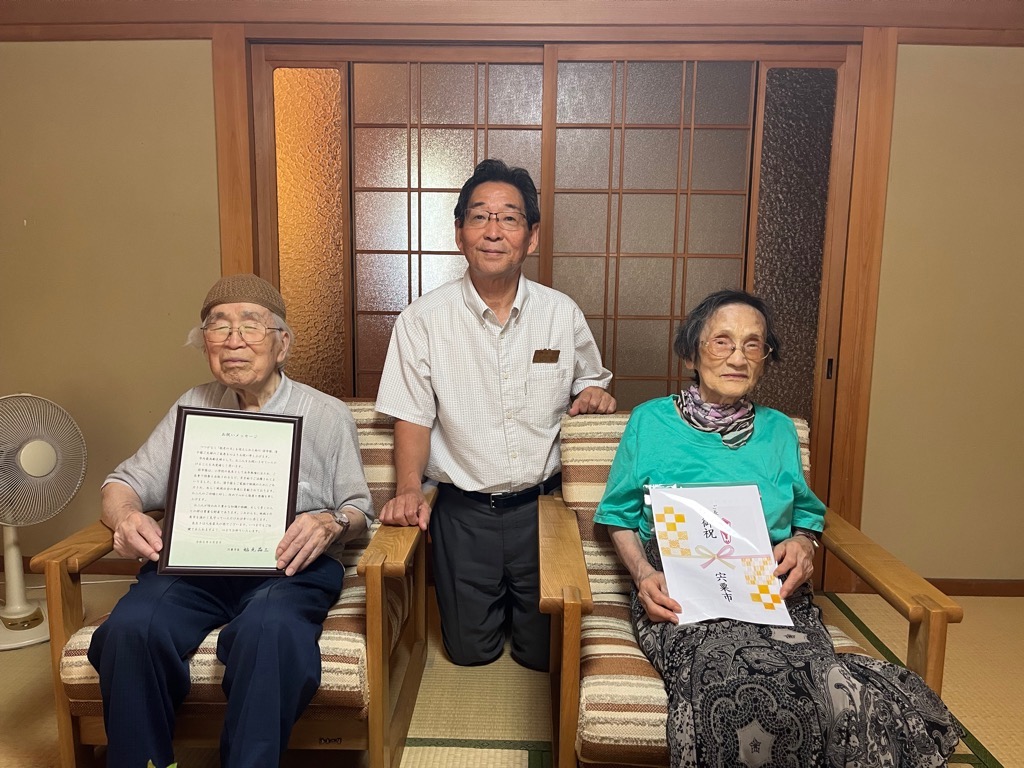市内最高齢者夫婦と福元市長の3人が並んで正面を向いている写真