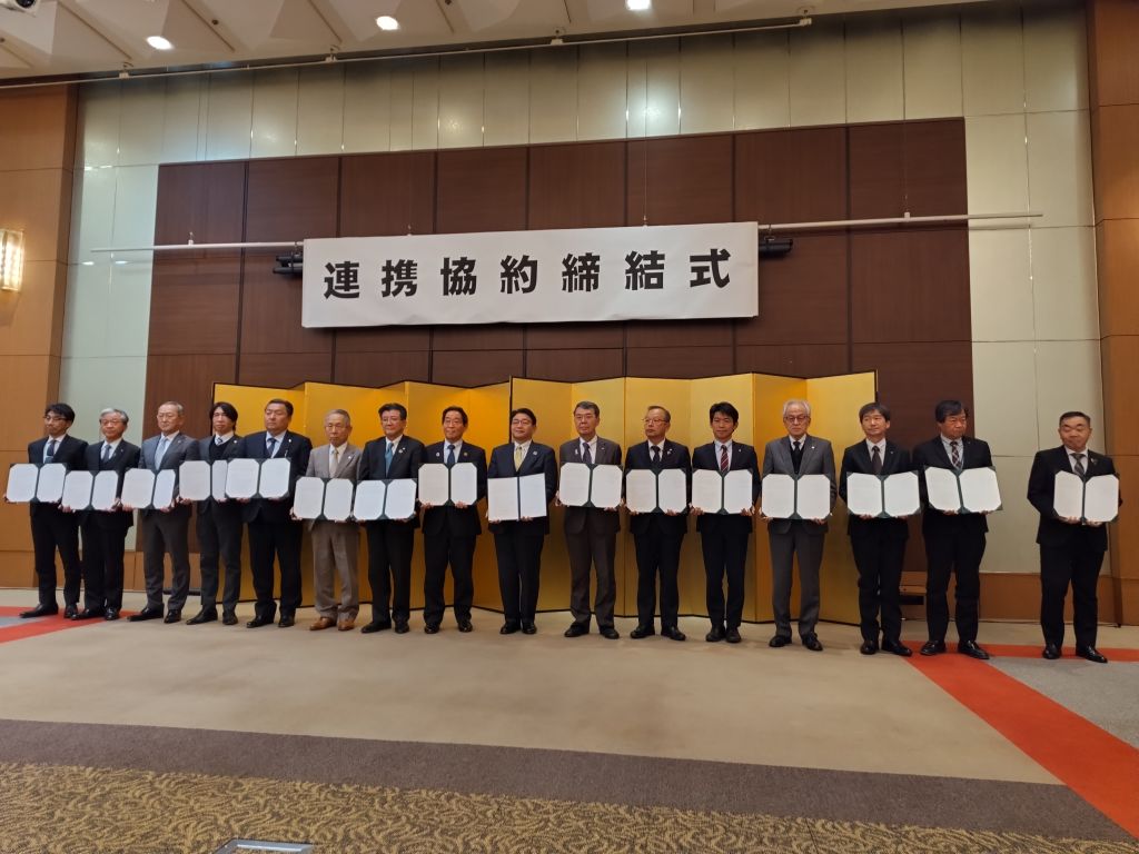 連携協約締結式で関係者らと横一列に並ぶ福元市長の写真