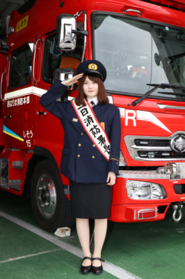 敬礼する一日消防署長に任命された光岡穂乃花さんの写真