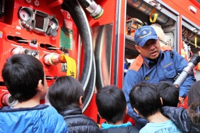 消防車の装備を見学する子どもたちの写真