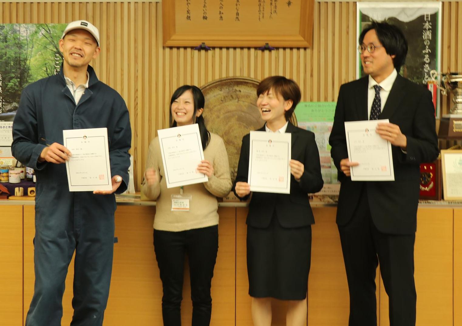 宍粟市地域おこし協力隊員4名が委嘱状をそれぞれの手に持ち笑顔を見せている写真