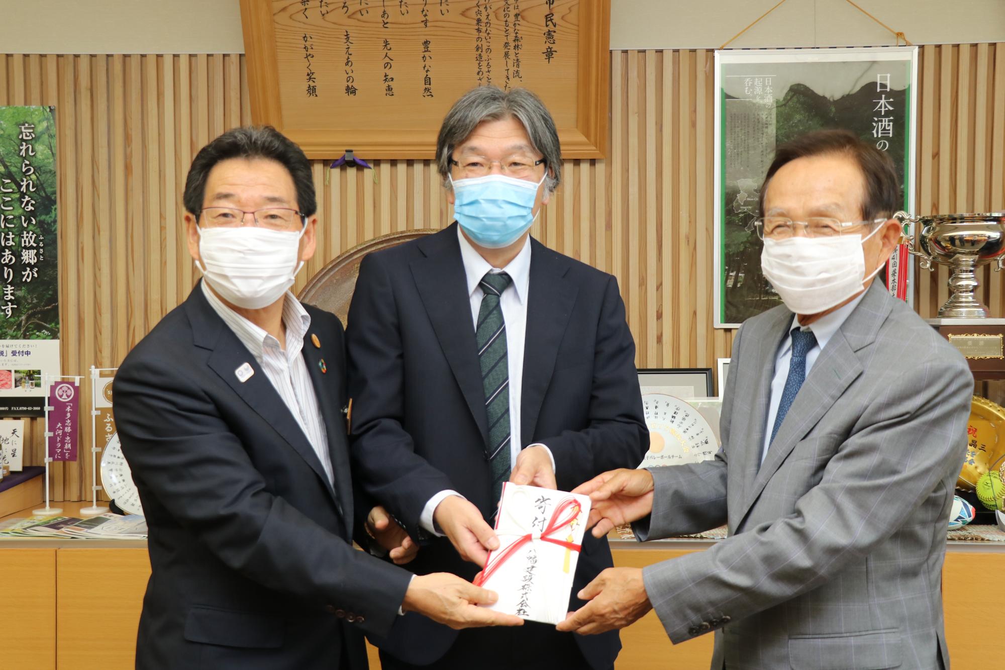 市長、医院長、八幡建設香山会長が目録を持つ写真