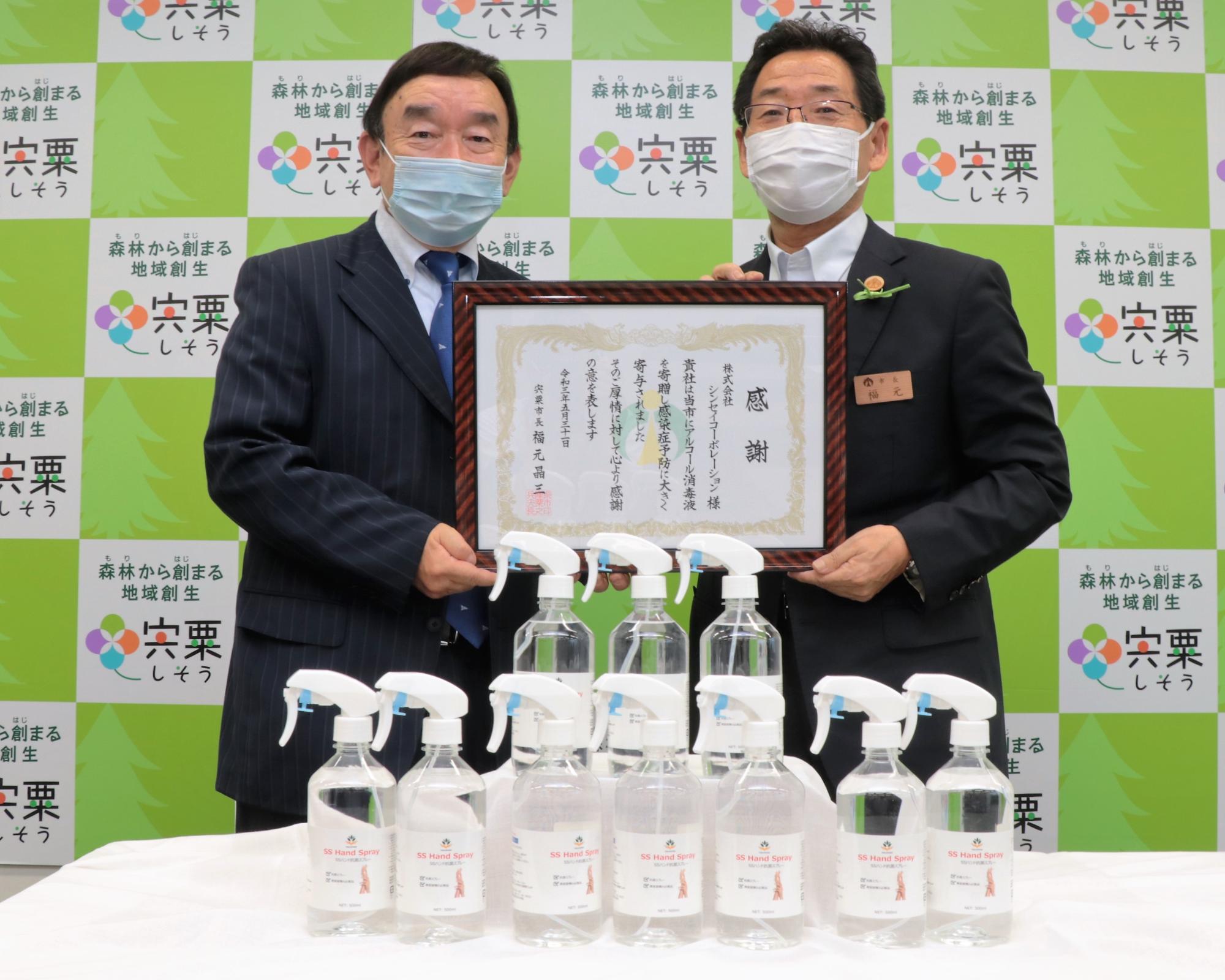 株式会社シンセイコーポレーション代表取締役会長の大東敏郎氏と福元市長の二人が感謝状に手を添え並んで笑っている写真