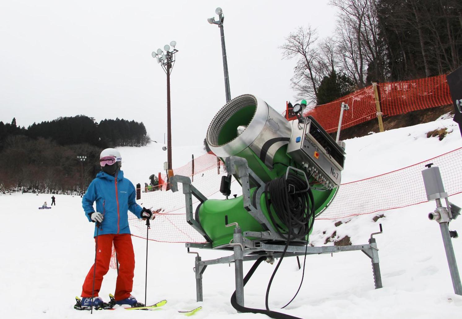 ちくさスキー場に新しく導入された降雪機とスキーヤーの写真