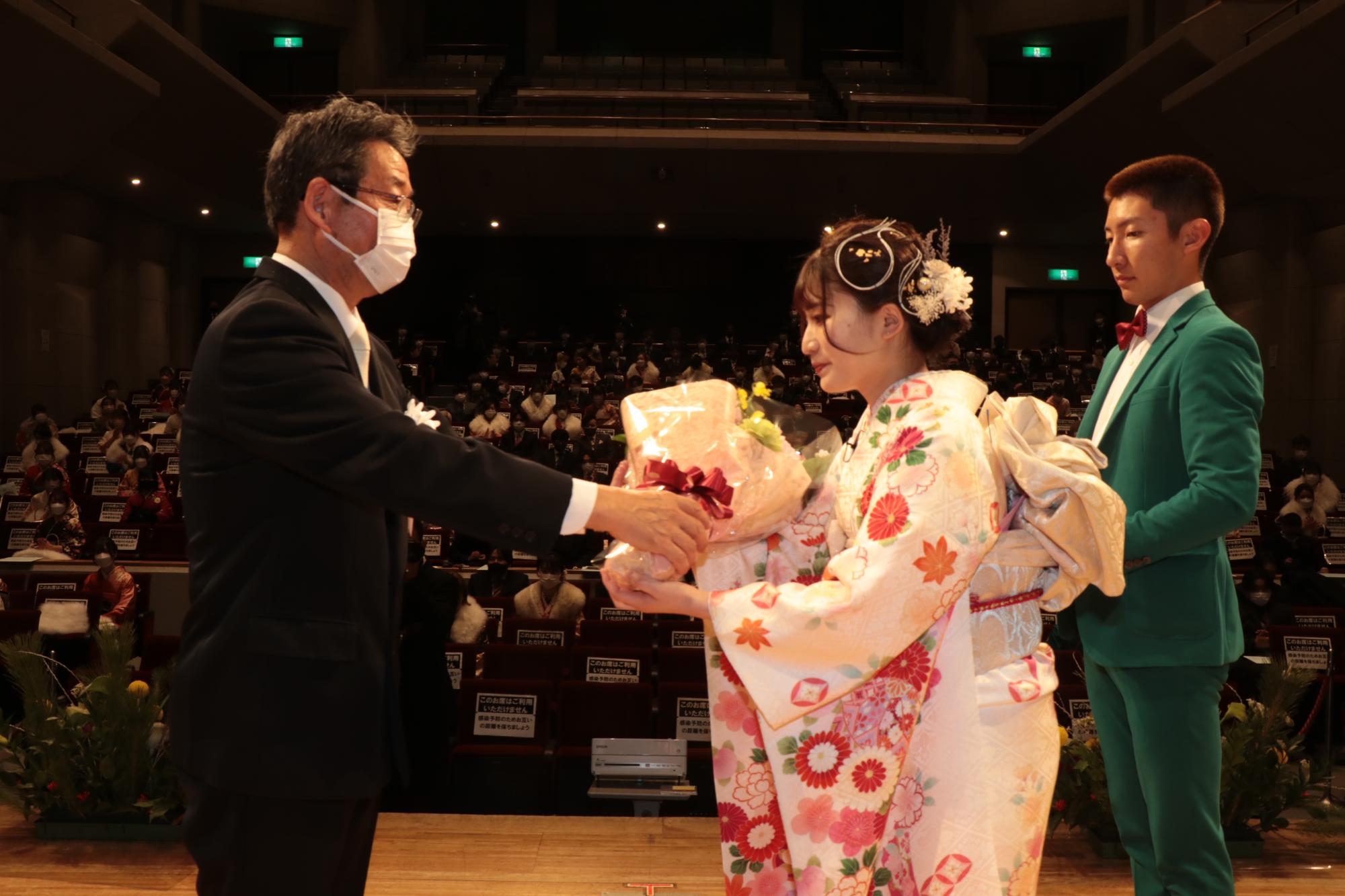 午前の部で新成人代表として市長から花束を受け取る瀧本朋花さん