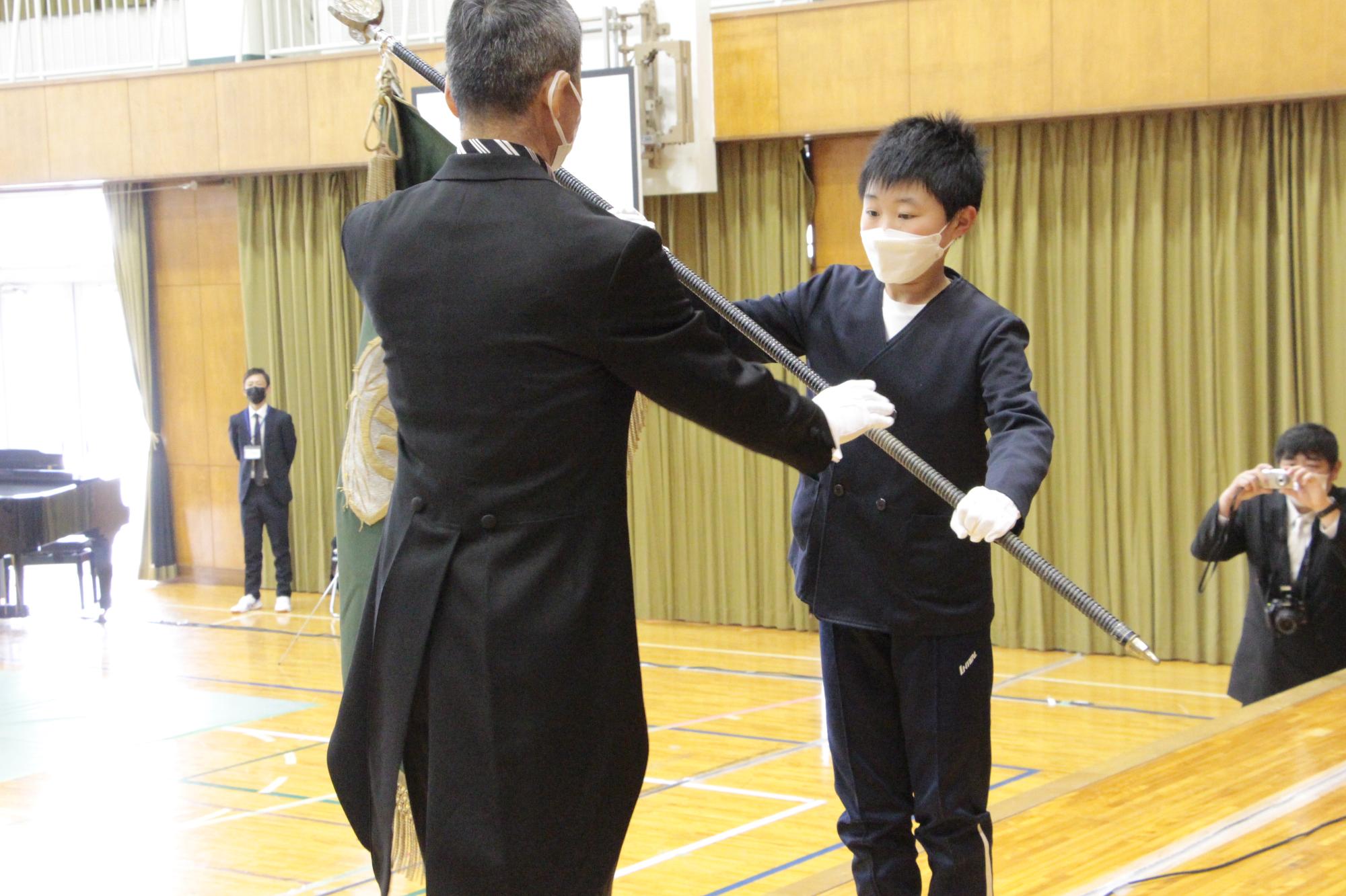 校旗を校長に返す内海さんの写真