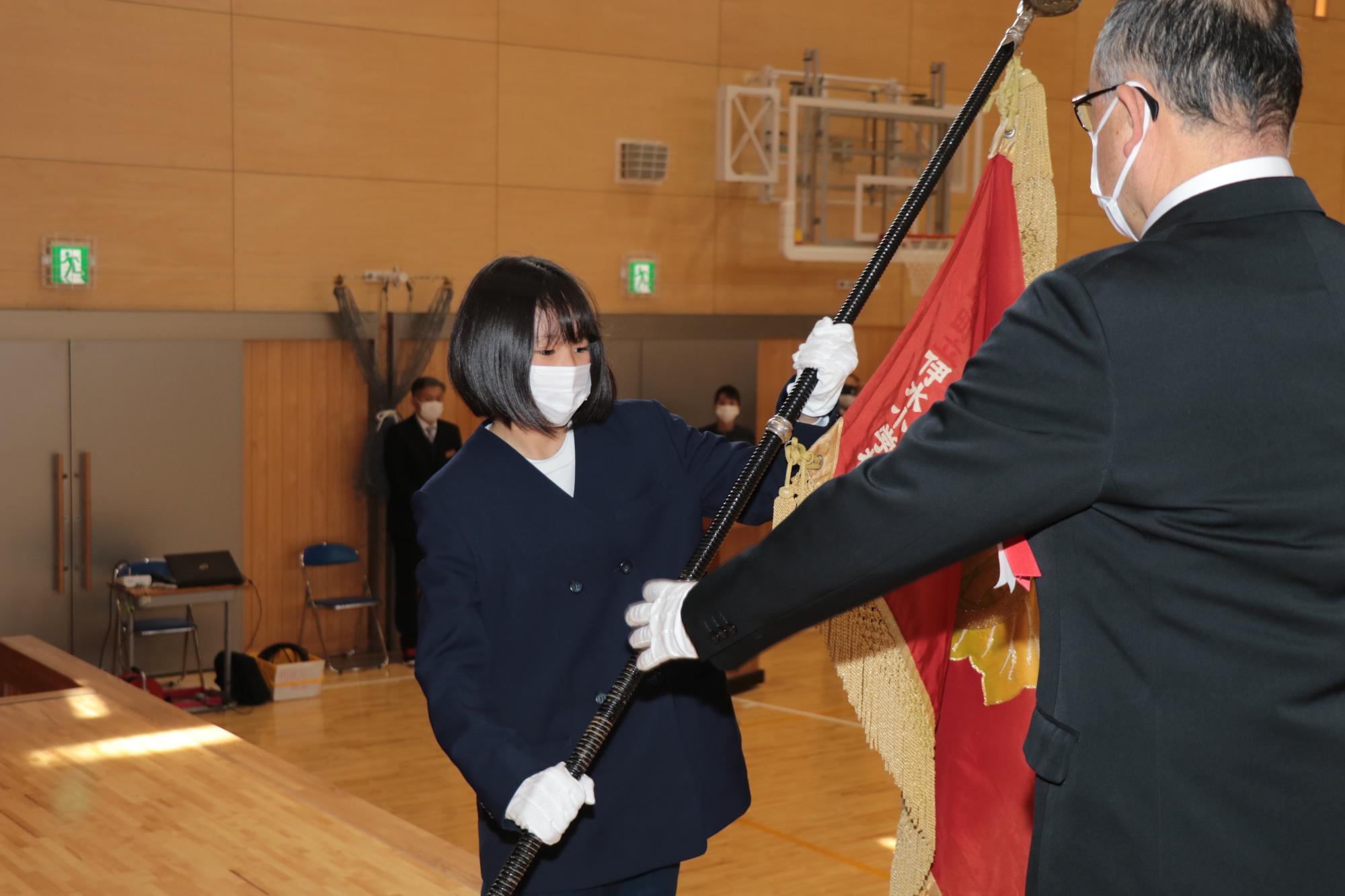 児童を代表して校旗を校長に返す6年の竹内柚希さん
