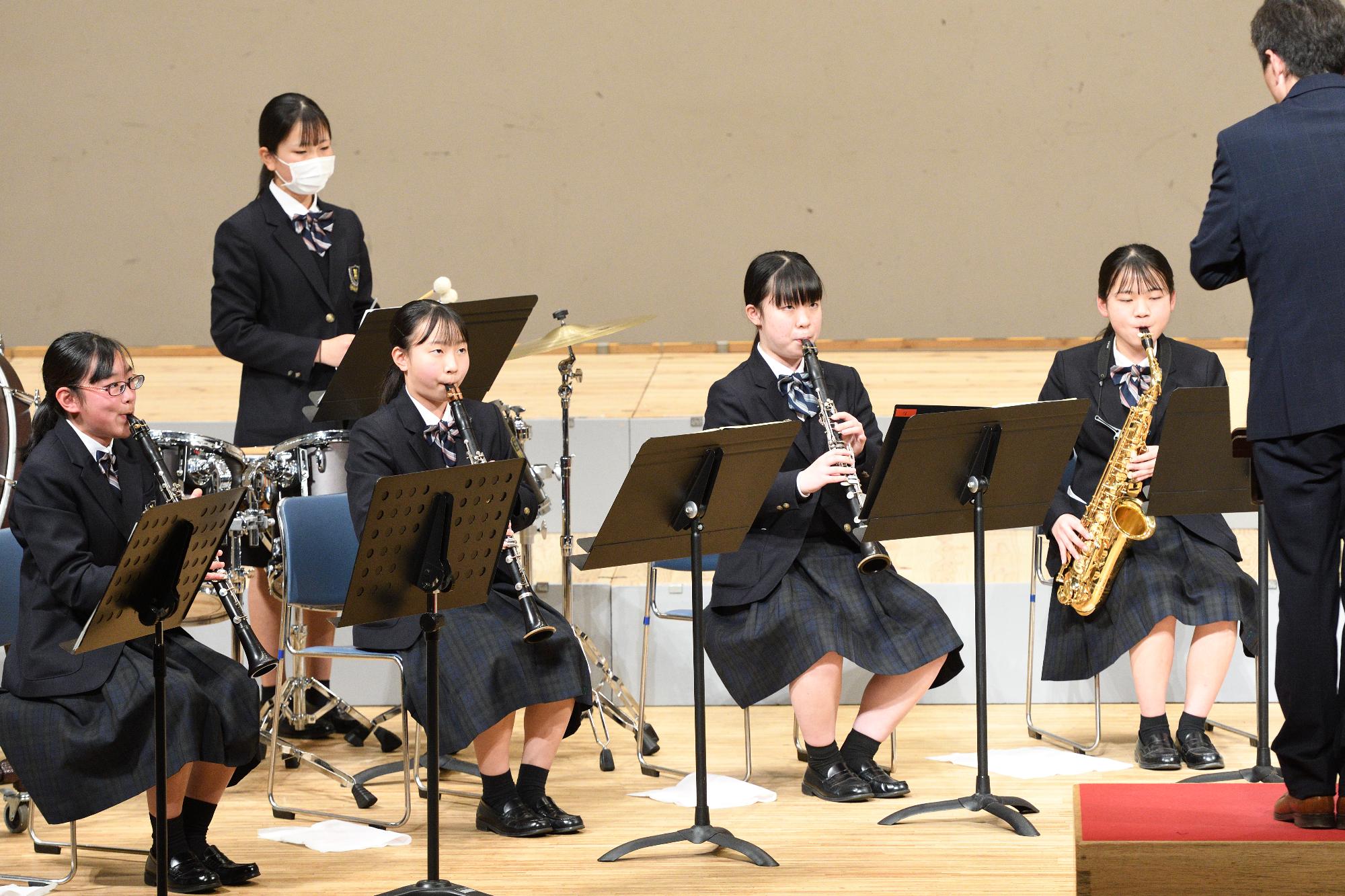 山崎文化会館のステージで演奏を披露する山崎高校吹奏楽部の写真