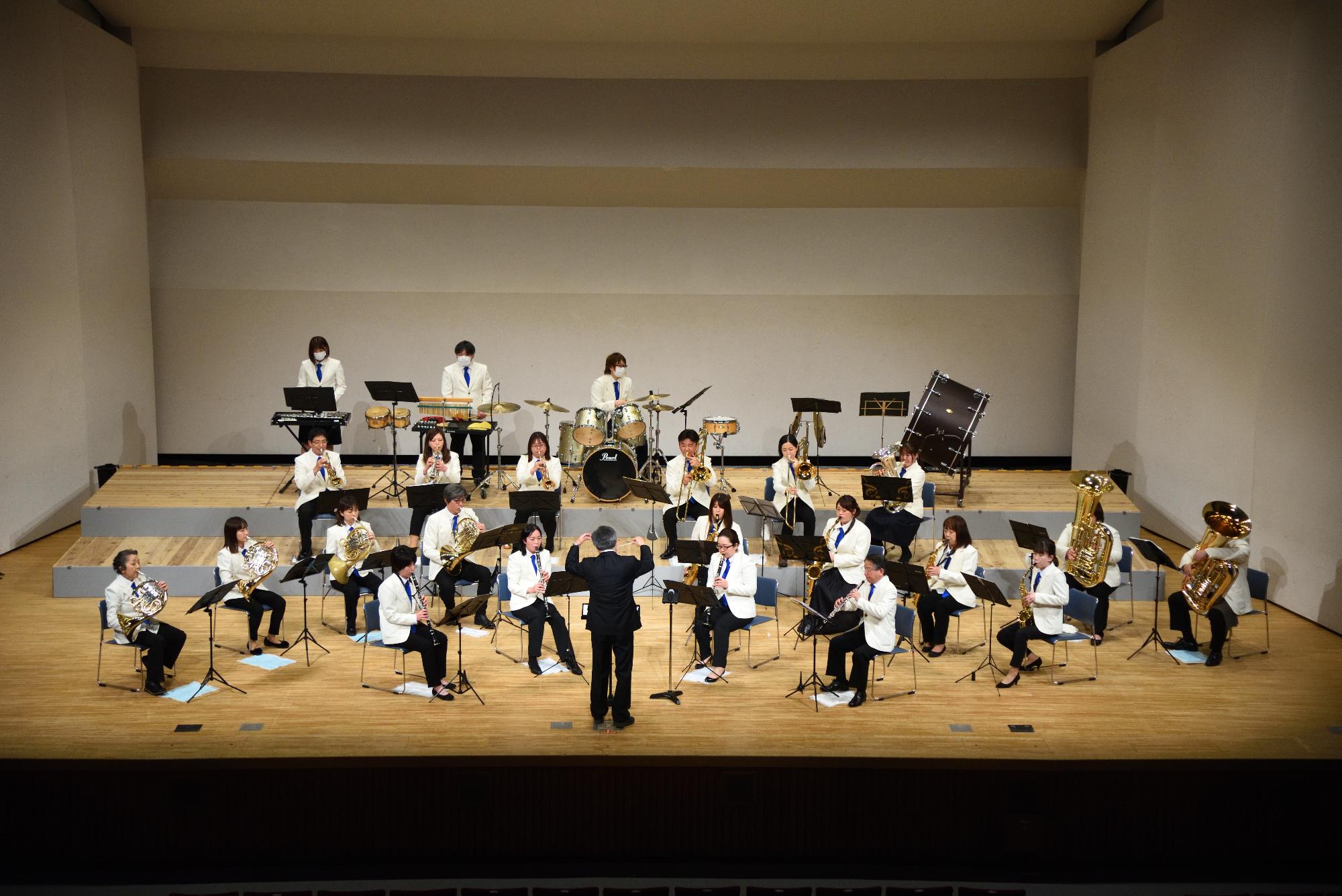山崎文化会館のステージで演奏を披露する宍粟市吹奏楽団の写真