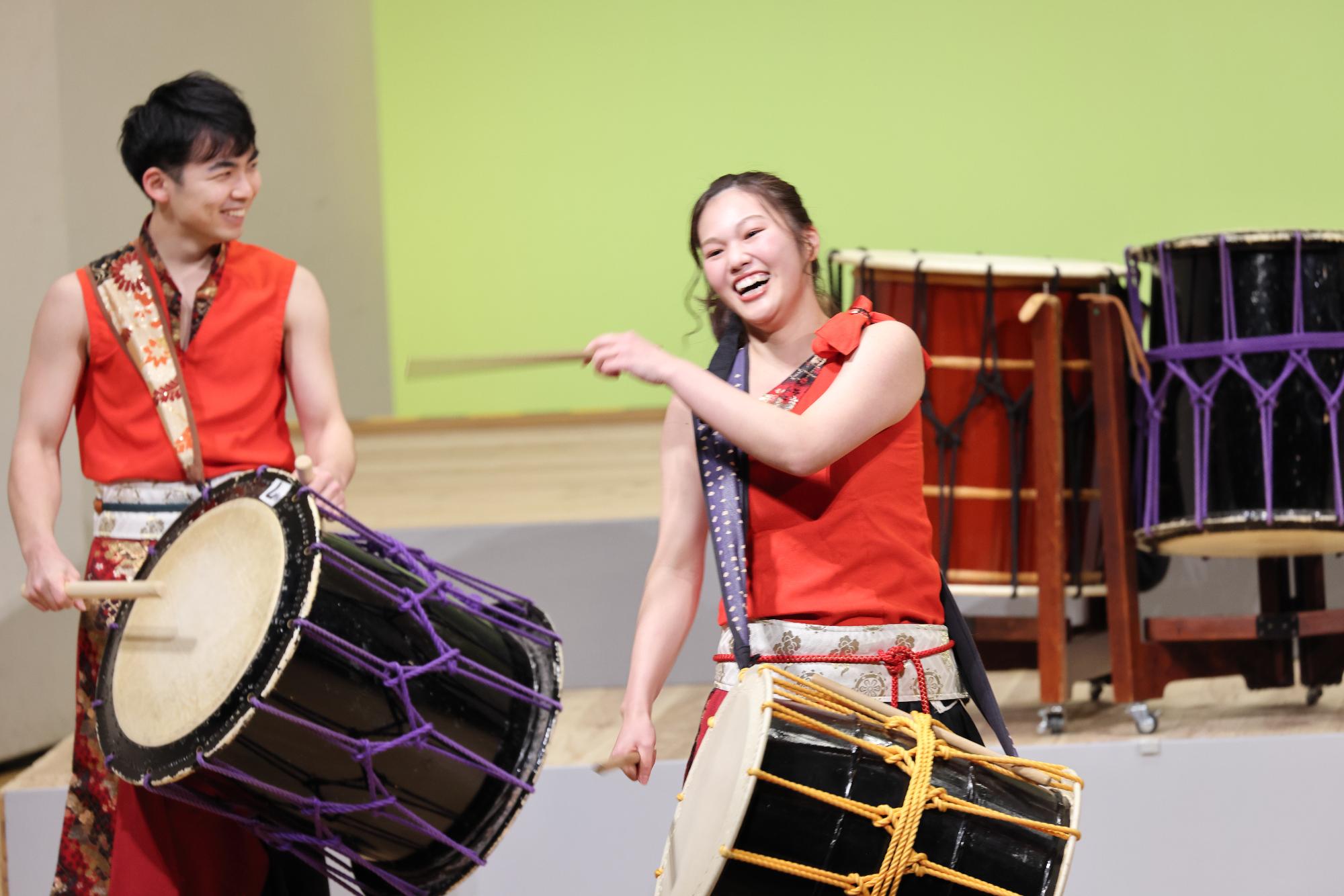 山崎文化会館のステージで力強いばちさばきを見せる和太鼓演奏グループ「彈紅（だんく）」の写真