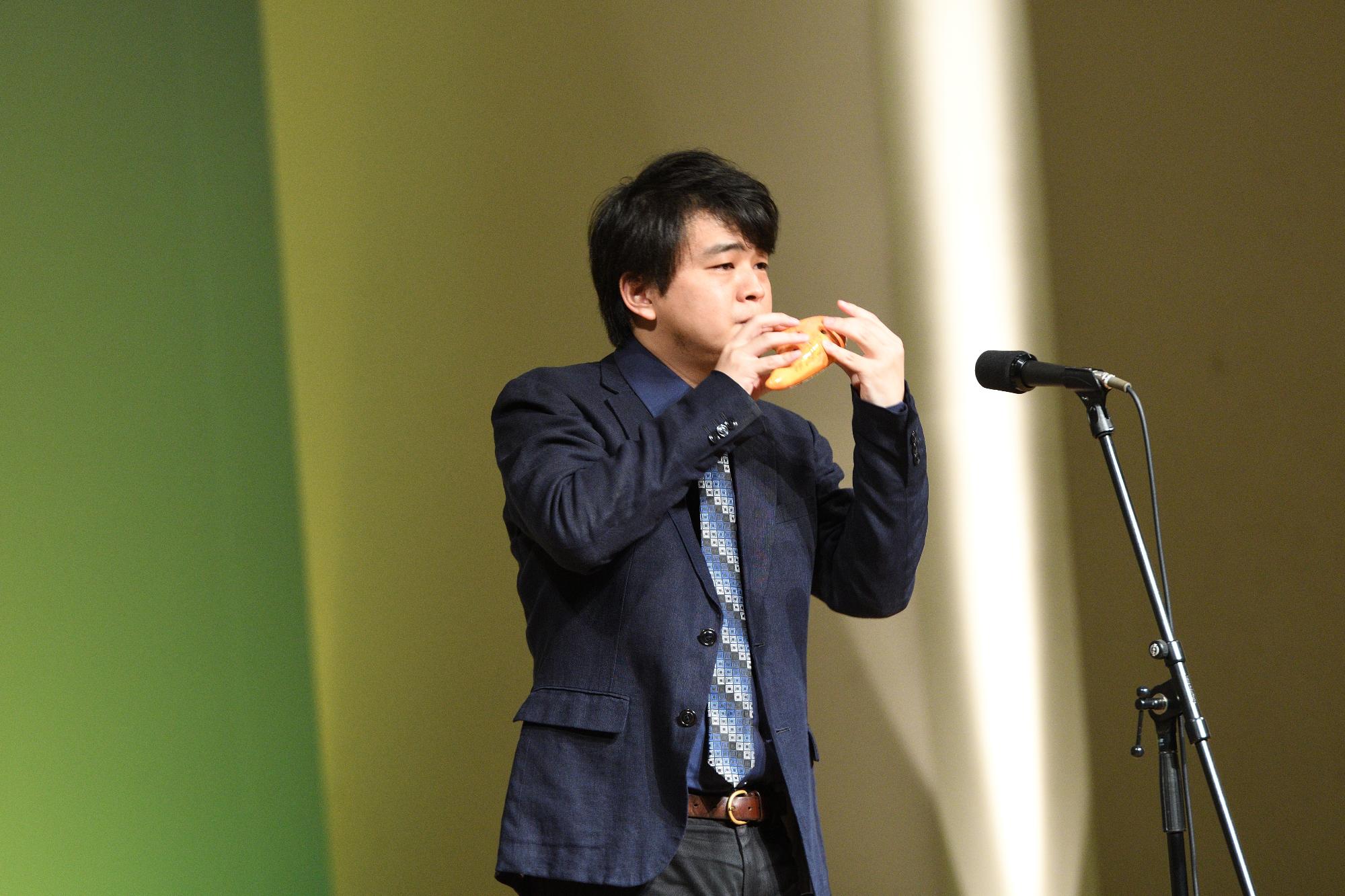 山崎文化会館のステージでオカリナの音色を響かせる茨木智博さんの写真