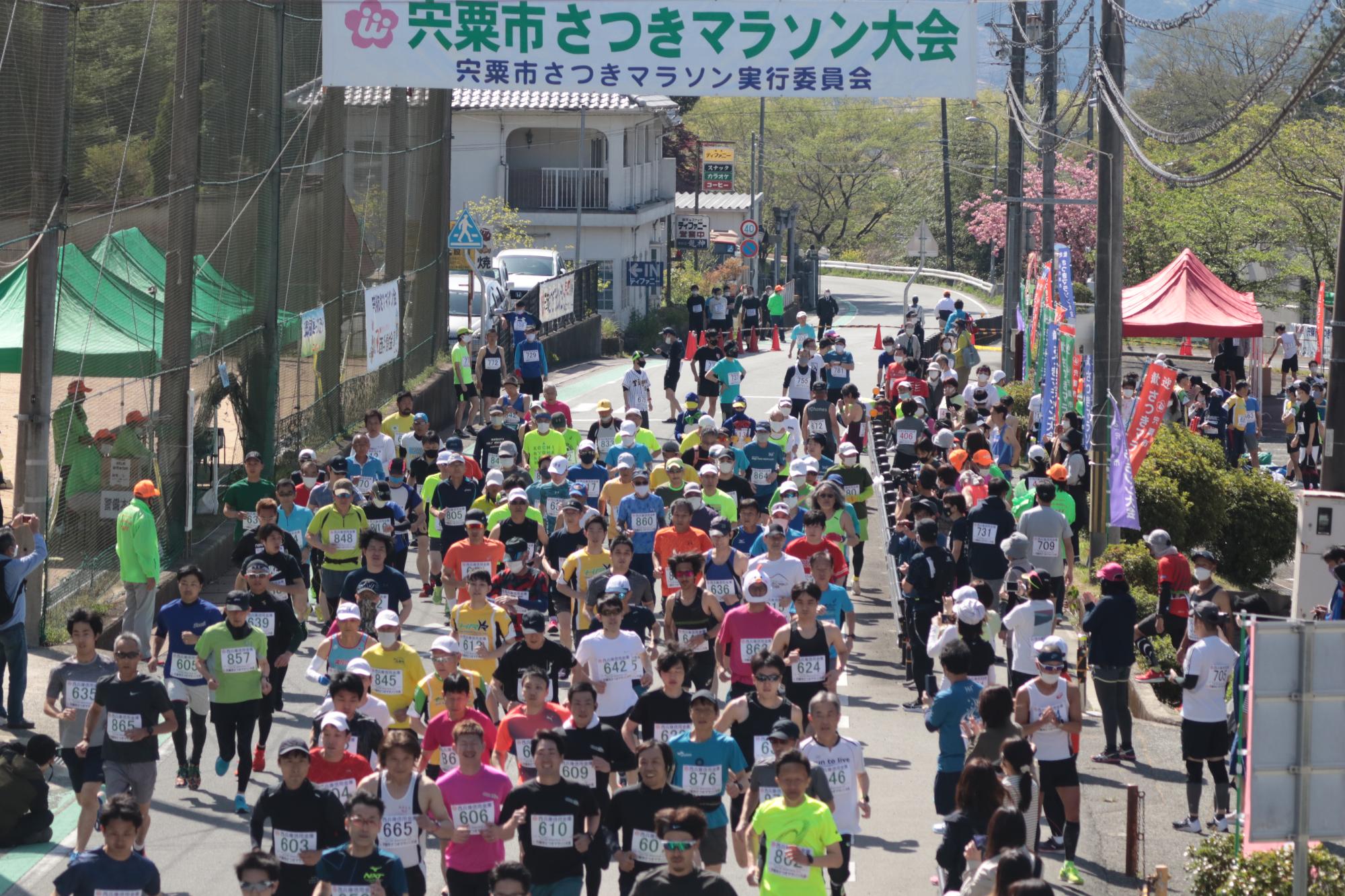 山崎スポーツセンター前の道路から号砲とともに一斉にスタートを切るランナーの写真