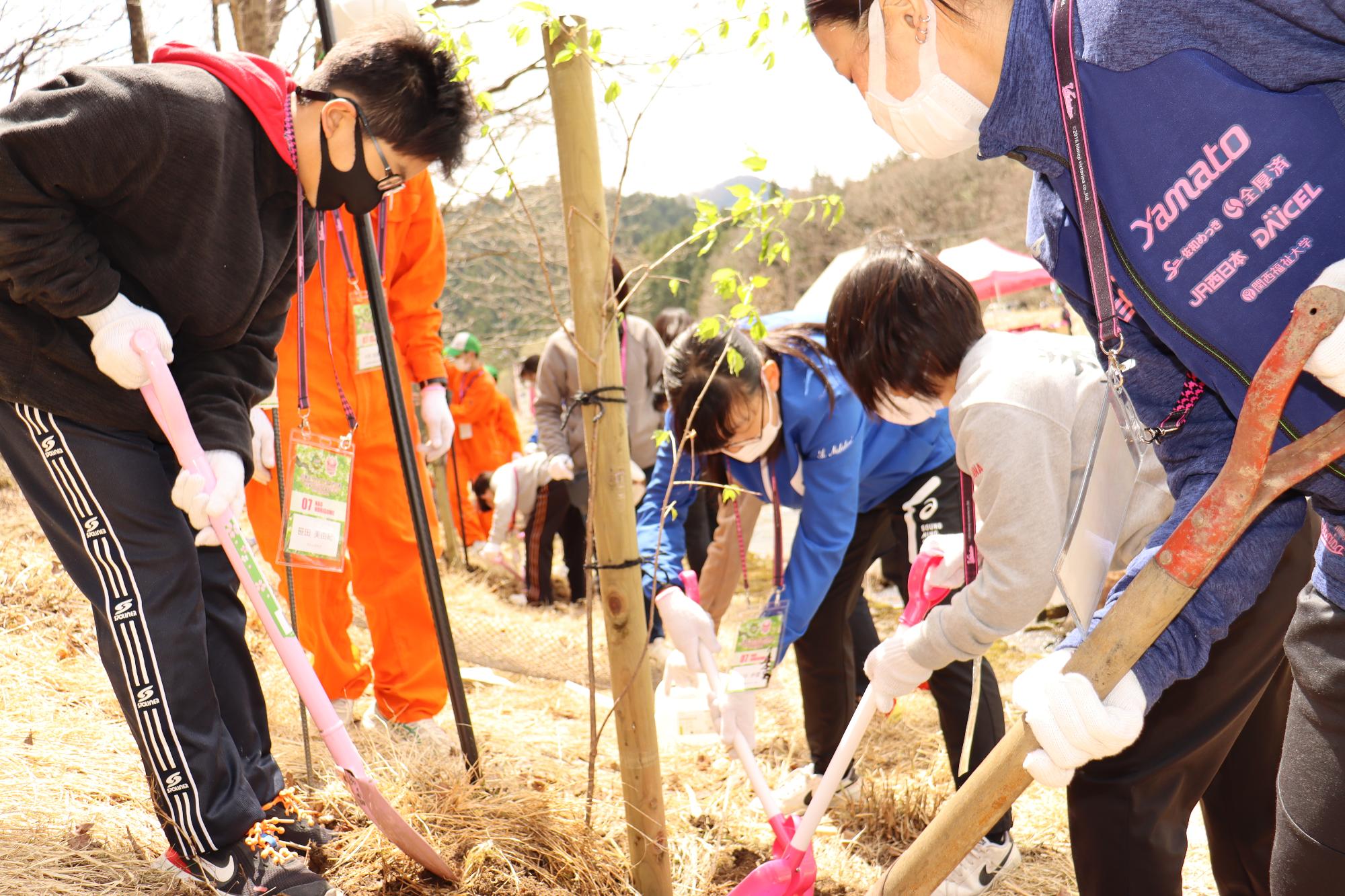 選手と苗木を植樹する子どもたち