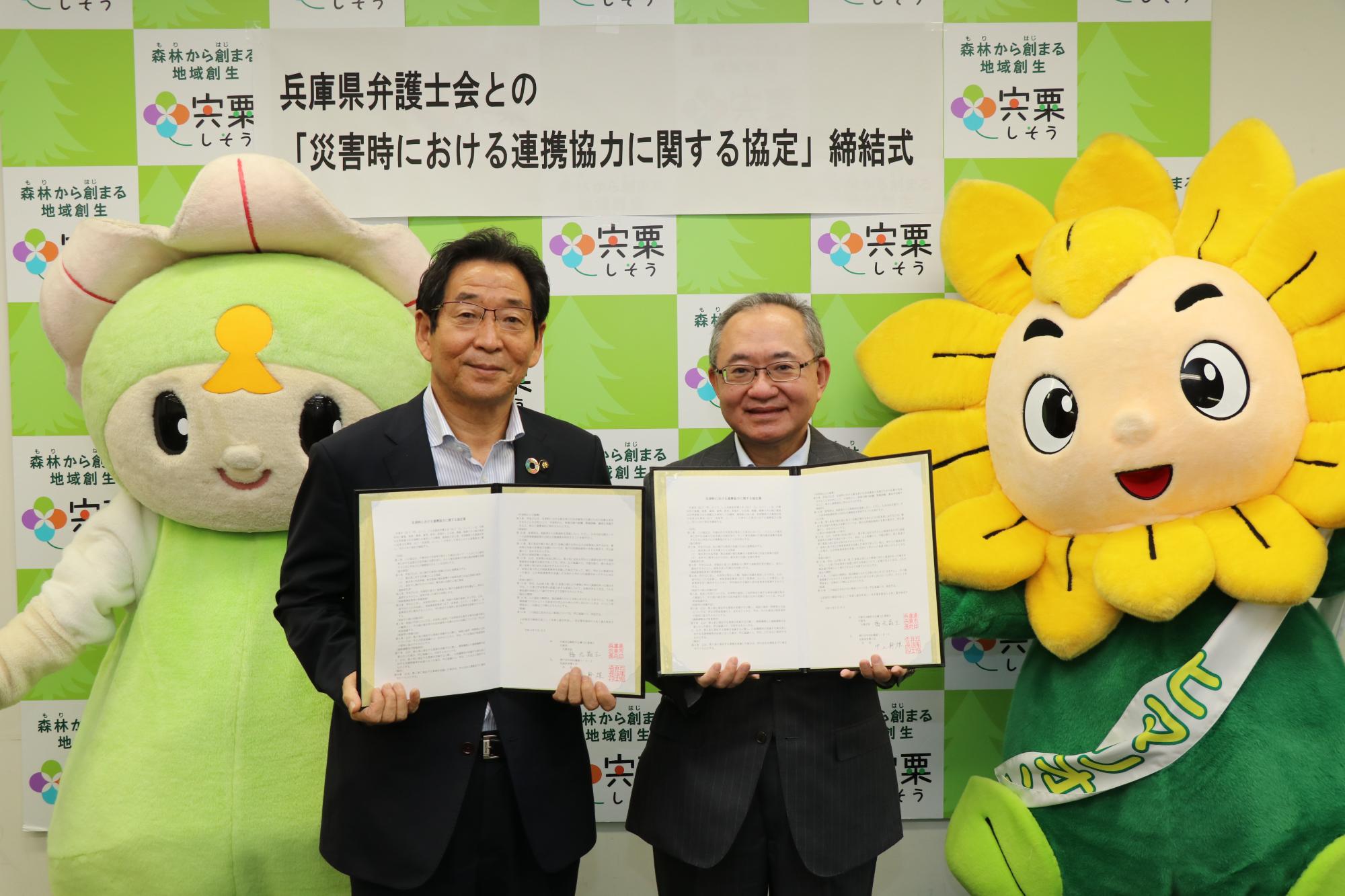 福元市長と兵庫県弁護士会の中上会長が協定書を持って並んでいる写真