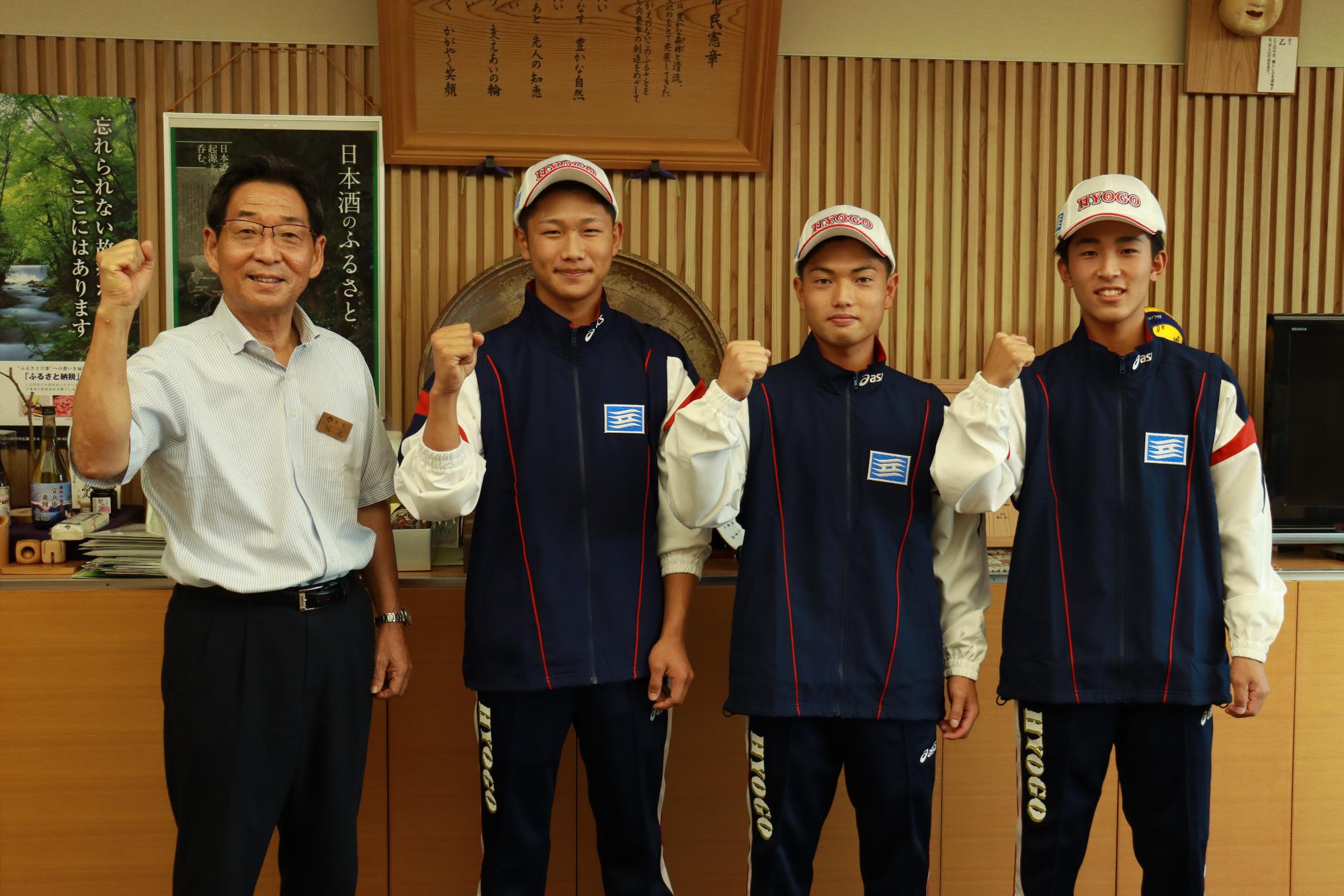 国体の兵庫県代表に選出された山崎高校ソフトボール部の3人が福元市長と並んでガッツポーズしている写真