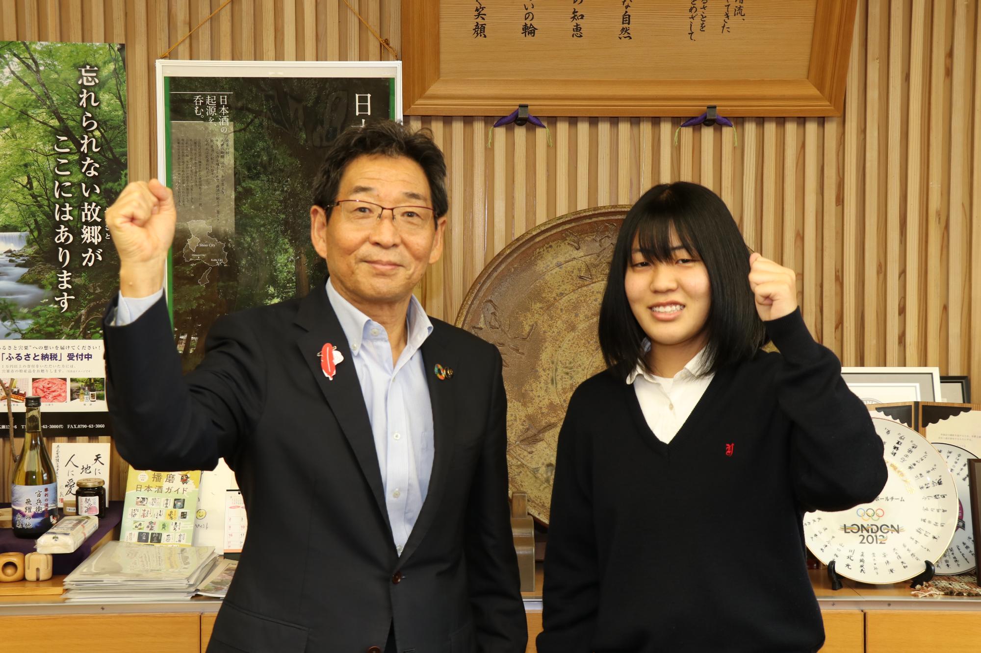 全国大会に出場する山崎高校の秦さんと市長が並んでガッツポーズしている写真