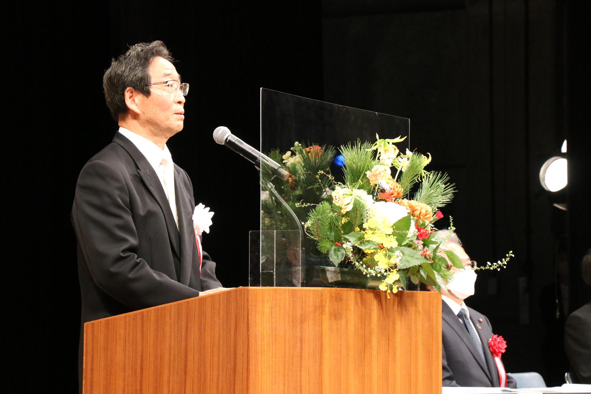 山崎文化会館のステージ上から若者たちに向かって祝辞を述べる福元市長の写真