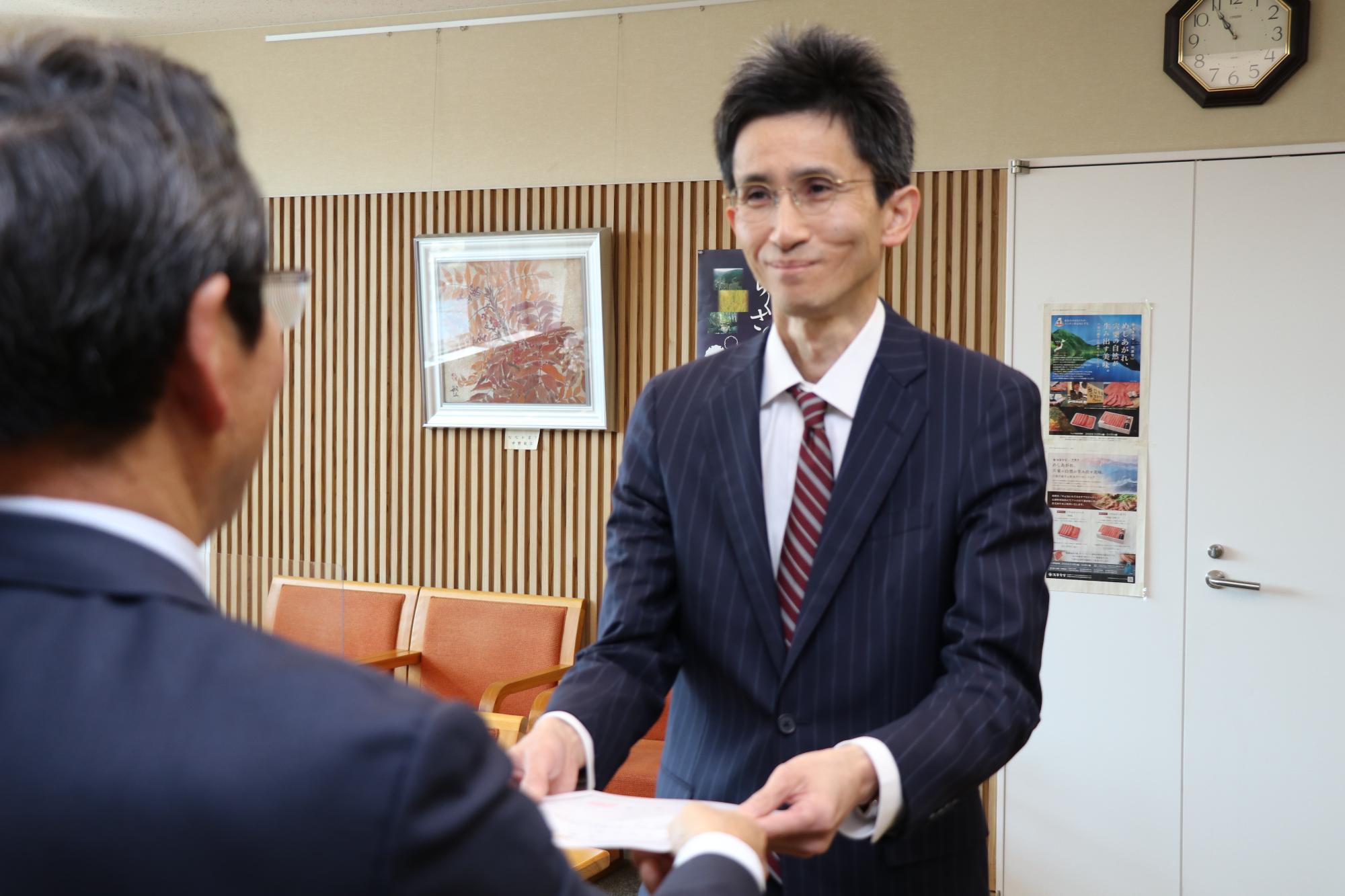 市長室で新協力隊の内海さんが福元市長と向き合い、市長から委嘱状を受け取っている写真