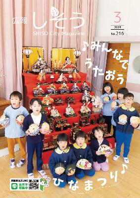 広報しそう3月号表紙：ひな飾りの周りに手作りのひな人形を手に持って並び、歌を歌いながらひな祭りを祝う山崎・城下幼稚園の園児らの写真