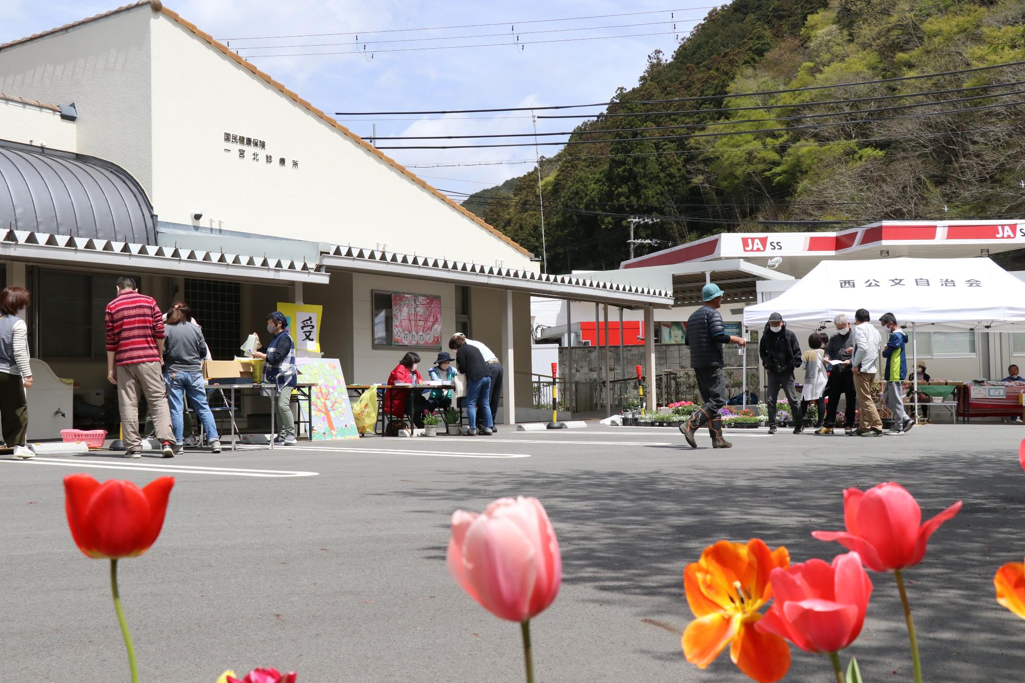 一宮北診療所の駐車場に集まった地域住民らが会話を楽しんでいる写真