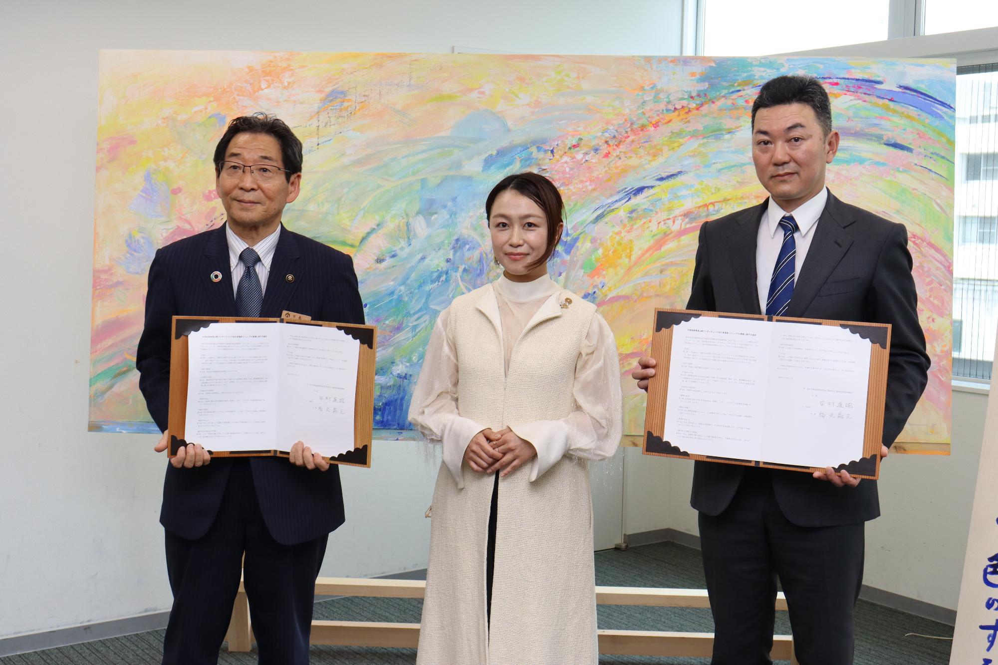 宍粟市出身の美術作家 植田志保さん（中）の両隣りにネクスコ西日本の福崎高速道路事務所 田村所長（右）と福元市長が協定書を手に並んで立っている写真