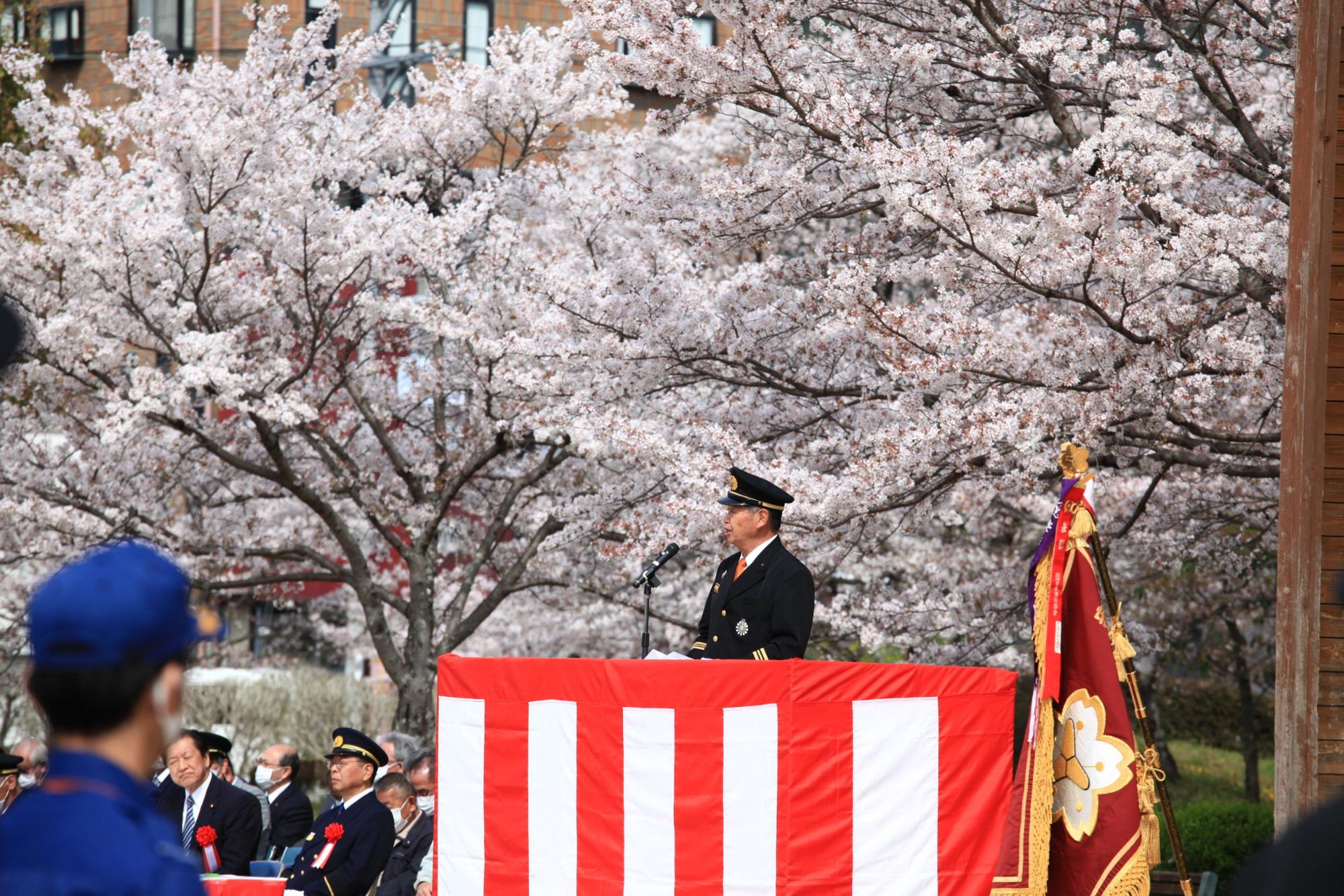 夢公園の会場で消防団員らに向かって訓示を述べる安原団長の写真