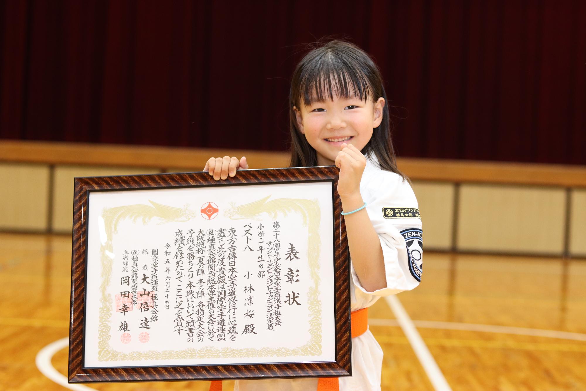 米山道場に通うはりま一宮小学校1年の小林凛桜さんが賞状を手に笑顔を見せている写真