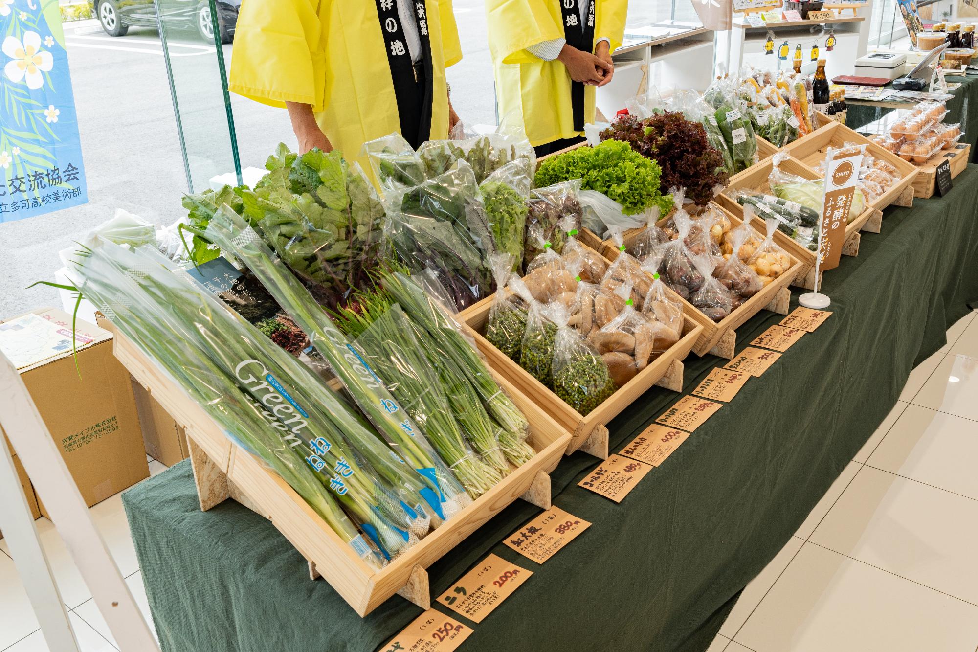 宍粟産の野菜などがトヨペット西脇店の店内にずらりと並べられている写真