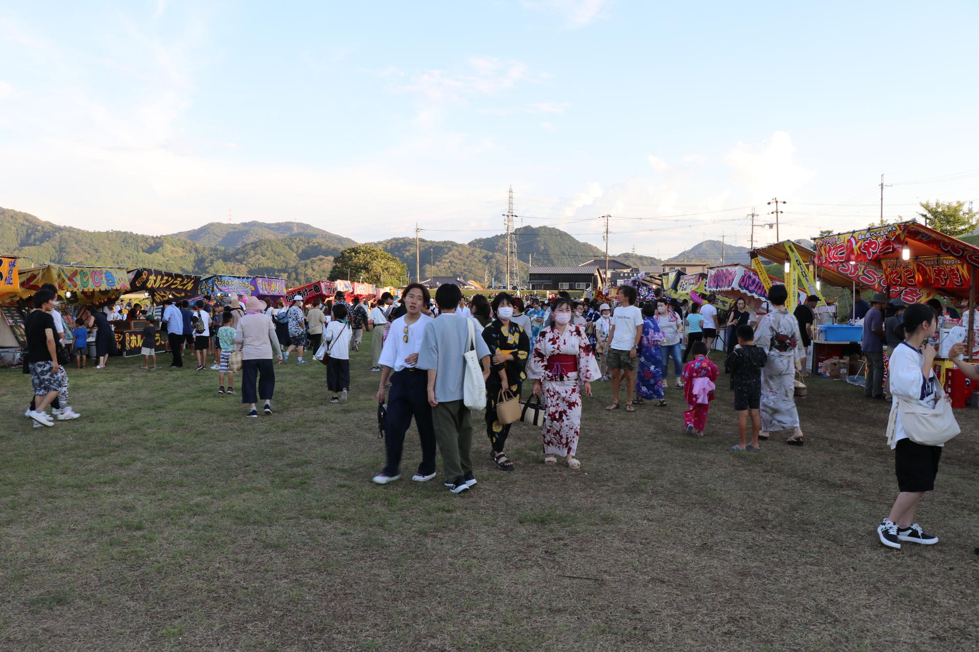 せせらぎ公園に並んだ露店で食べ物など買い物を楽しむ人たちの写真