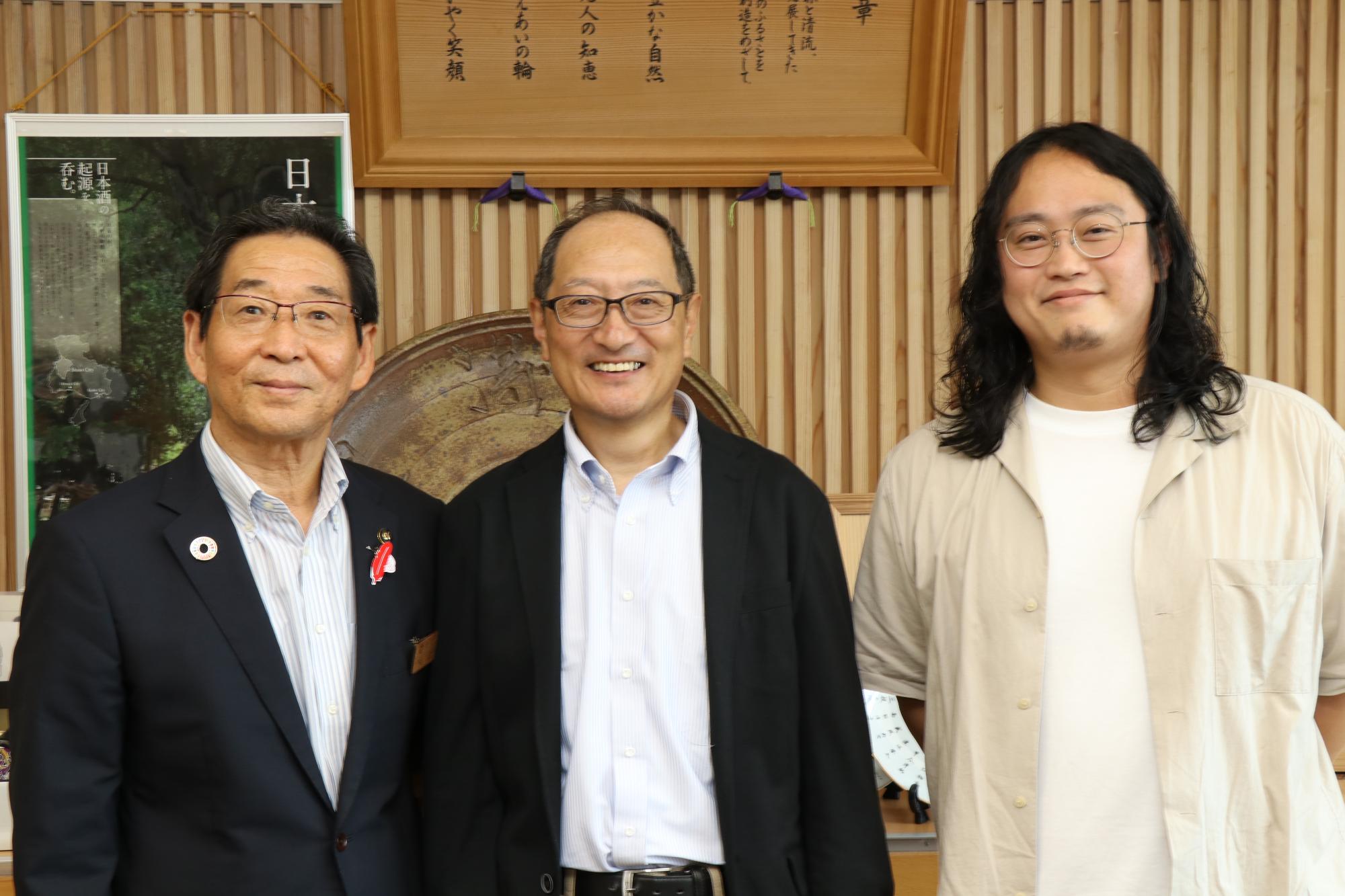 9月末で退任となった地域再生協働員の坂口さんと地域おこし協力隊の林さんが市長と並んで笑顔を見せている写真