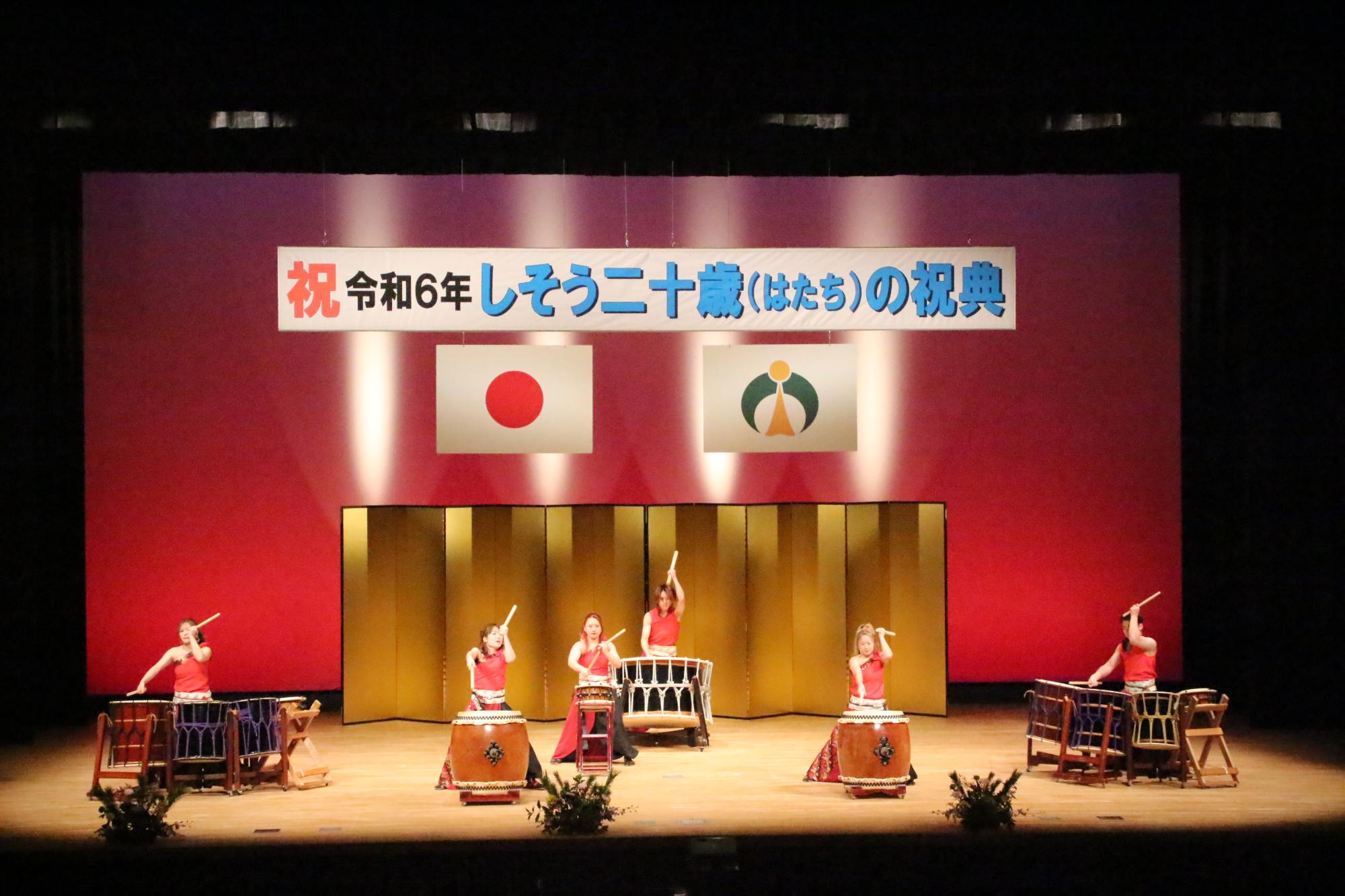 山崎文化会館のステージ上で新成人らを祝う和太鼓を披露する彈紅の写真