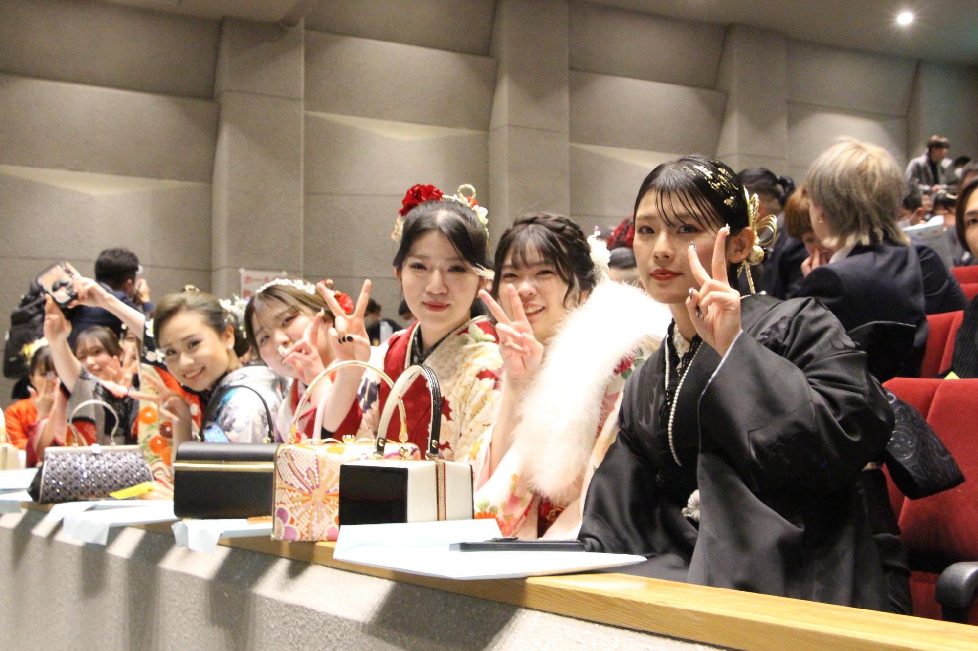 山崎文化会館館内でピースをして記念撮影に応じる若者らの写真
