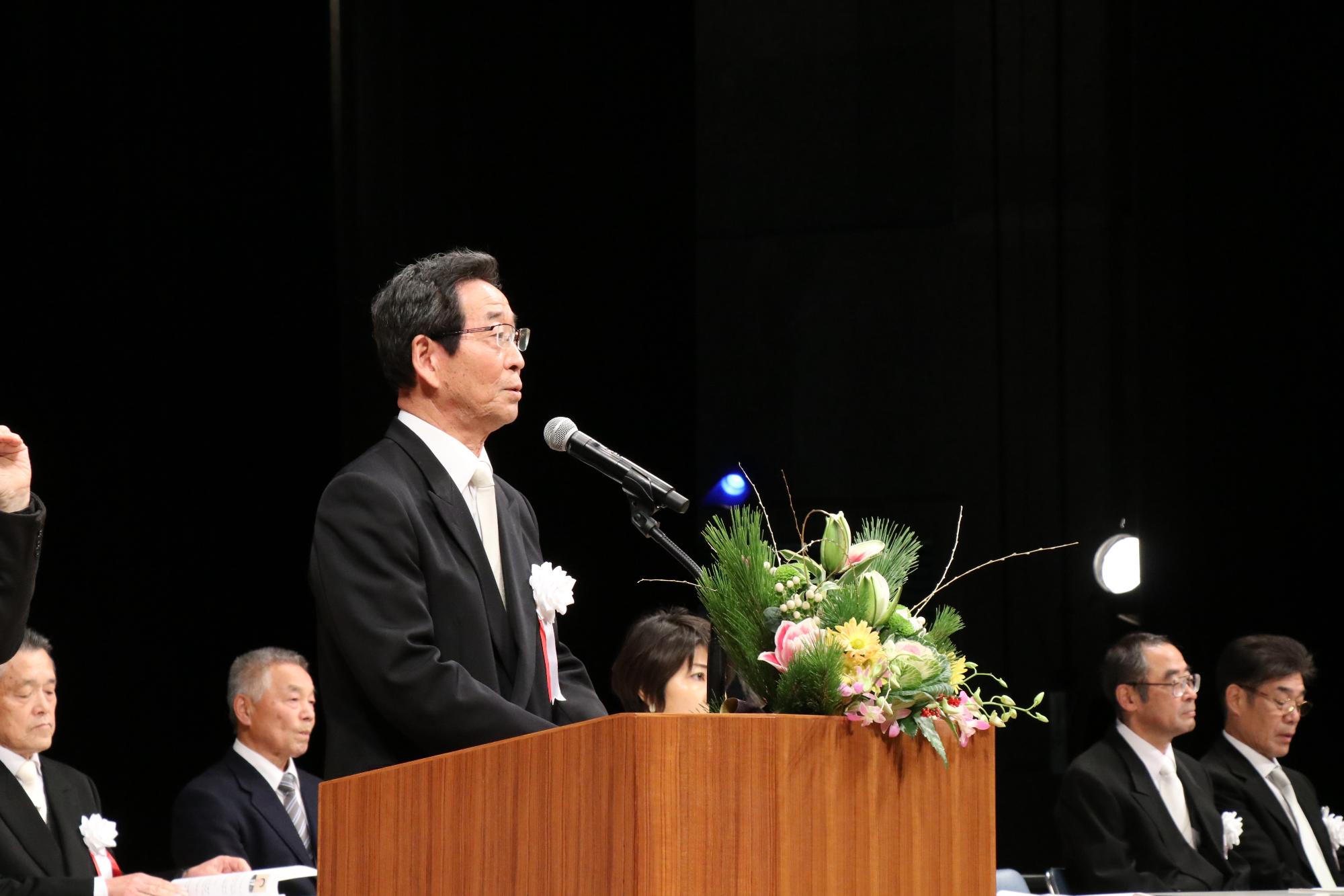 山崎文化会館のステージ上から若者たちに向かって祝辞を述べる福元市長の写真