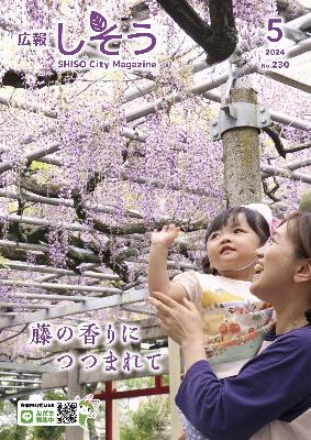 広報しそう5月号表紙：藤の花を見上げ手を伸ばしている子どもの写真
