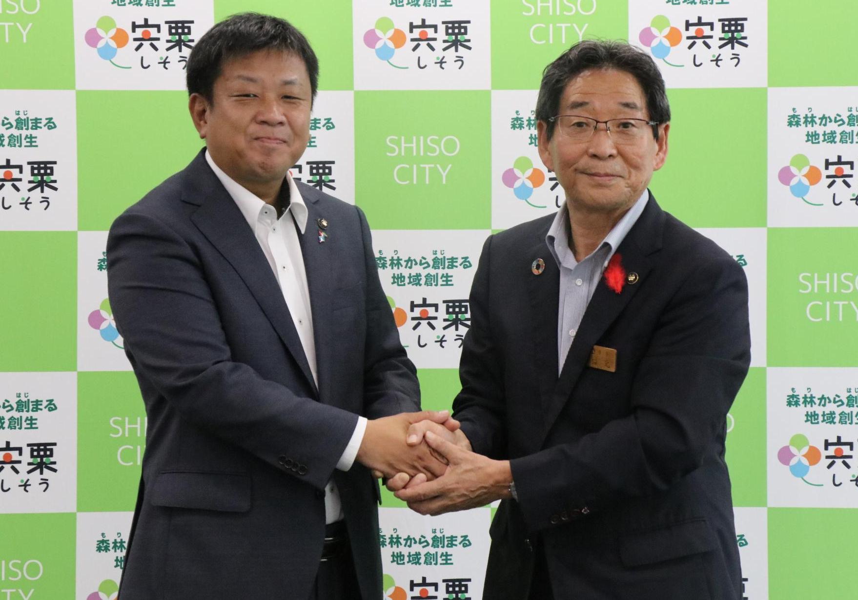 宍粟市役所に来庁されていた千葉県匝瑳市の宮内市長と福元市長が両手で握手している写真