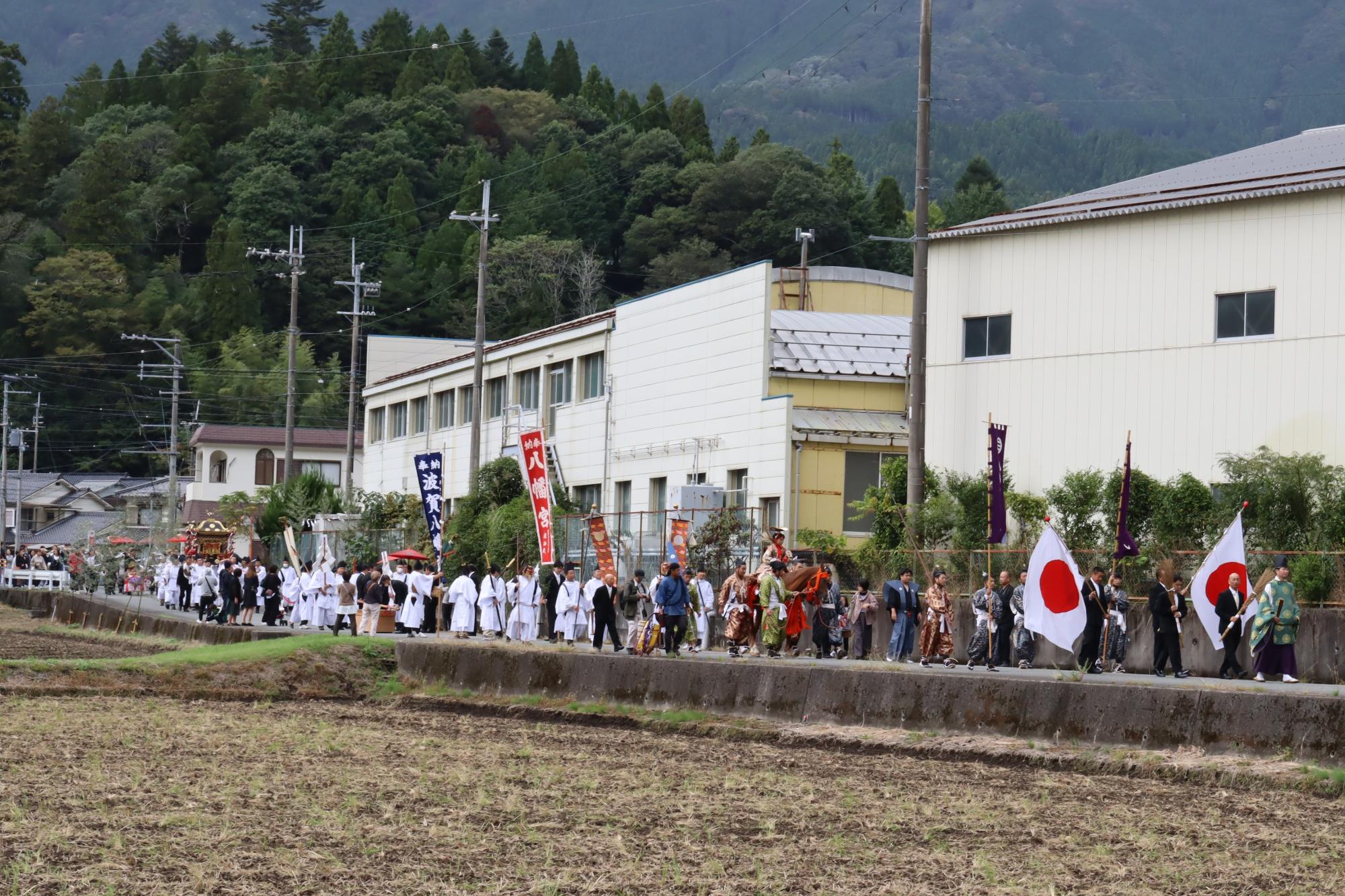 75役の人が列をなし、氏子地域を練り歩いている写真