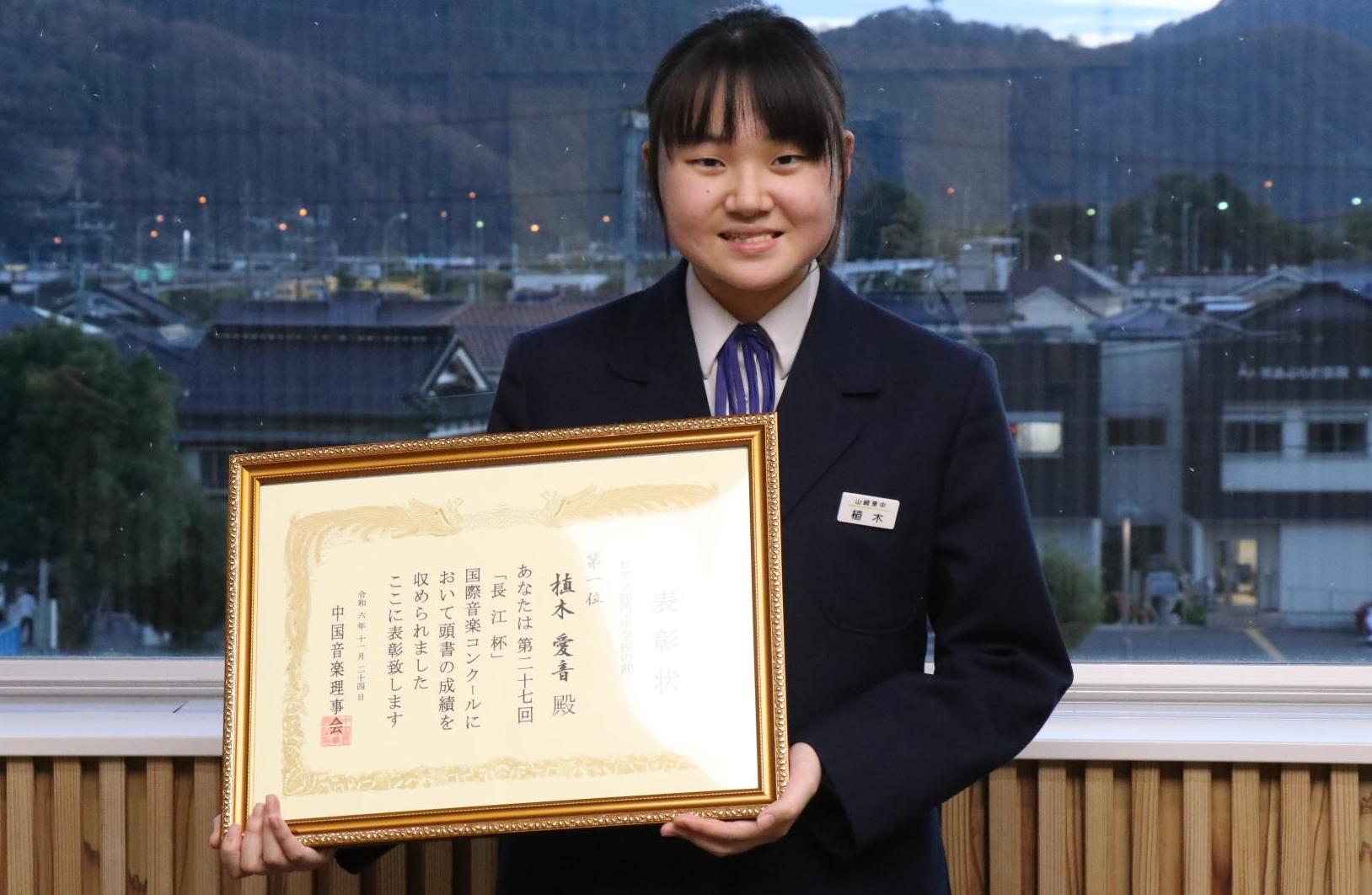 植木さんが賞状を手に持って正面を向いている写真