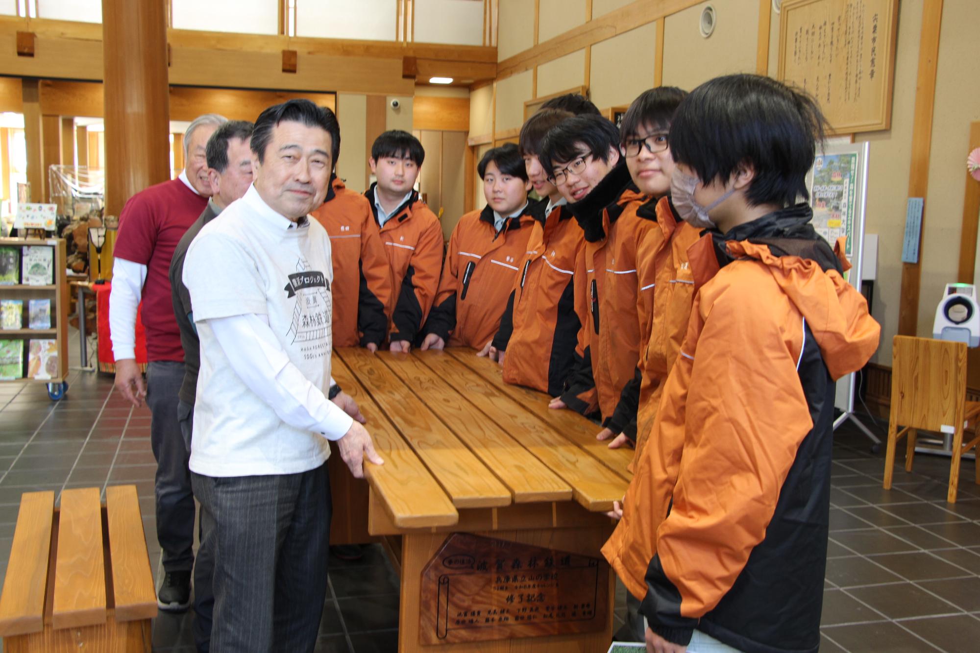 山の学校の生徒らが波賀元気づくりネットワーク協議会の人へ机と椅子を寄贈している様子の写真
