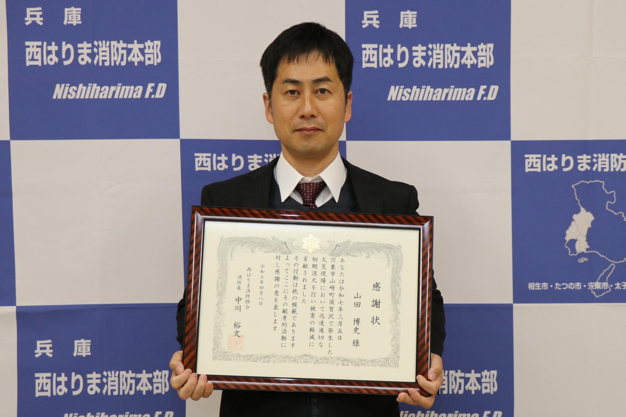 感謝状を手にした山田さん