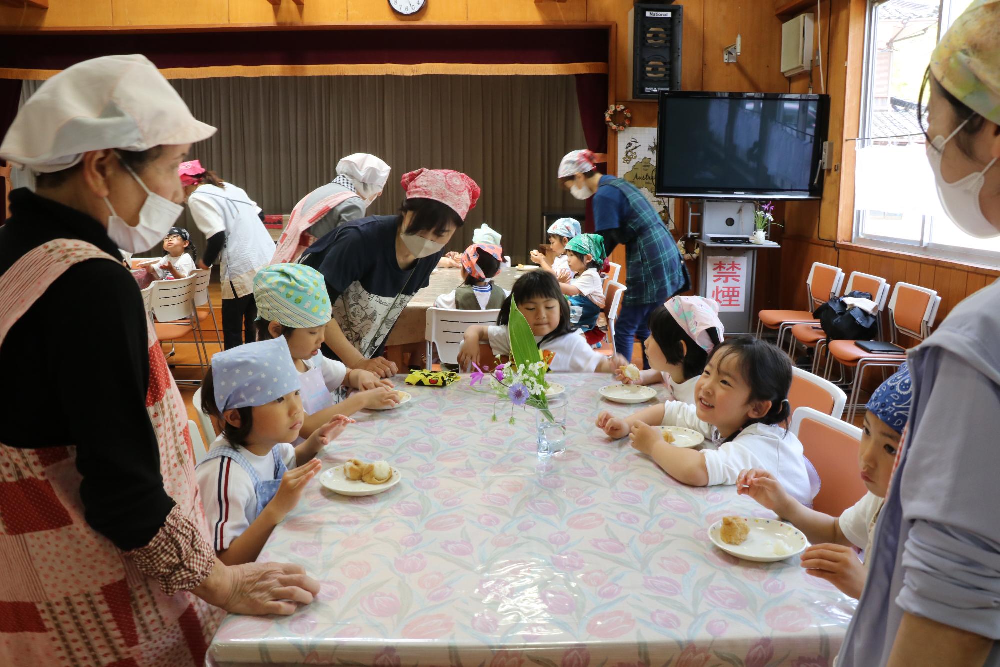 河東幼稚園児と波賀幼稚園児が一緒にいなり寿司をたべている様子