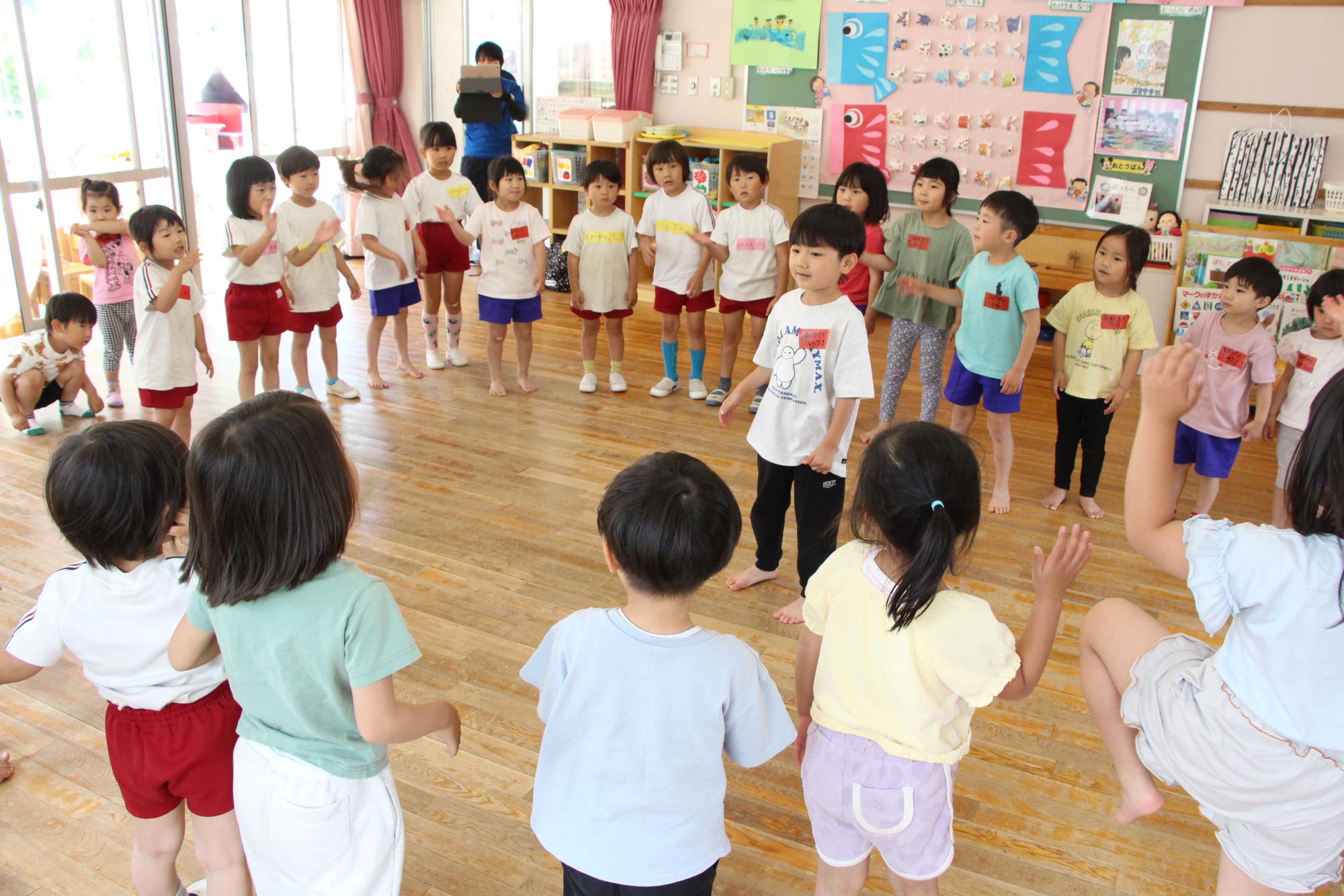 波賀幼稚園とみどり保育園の園児たちが輪になってリズム遊びをしている様子