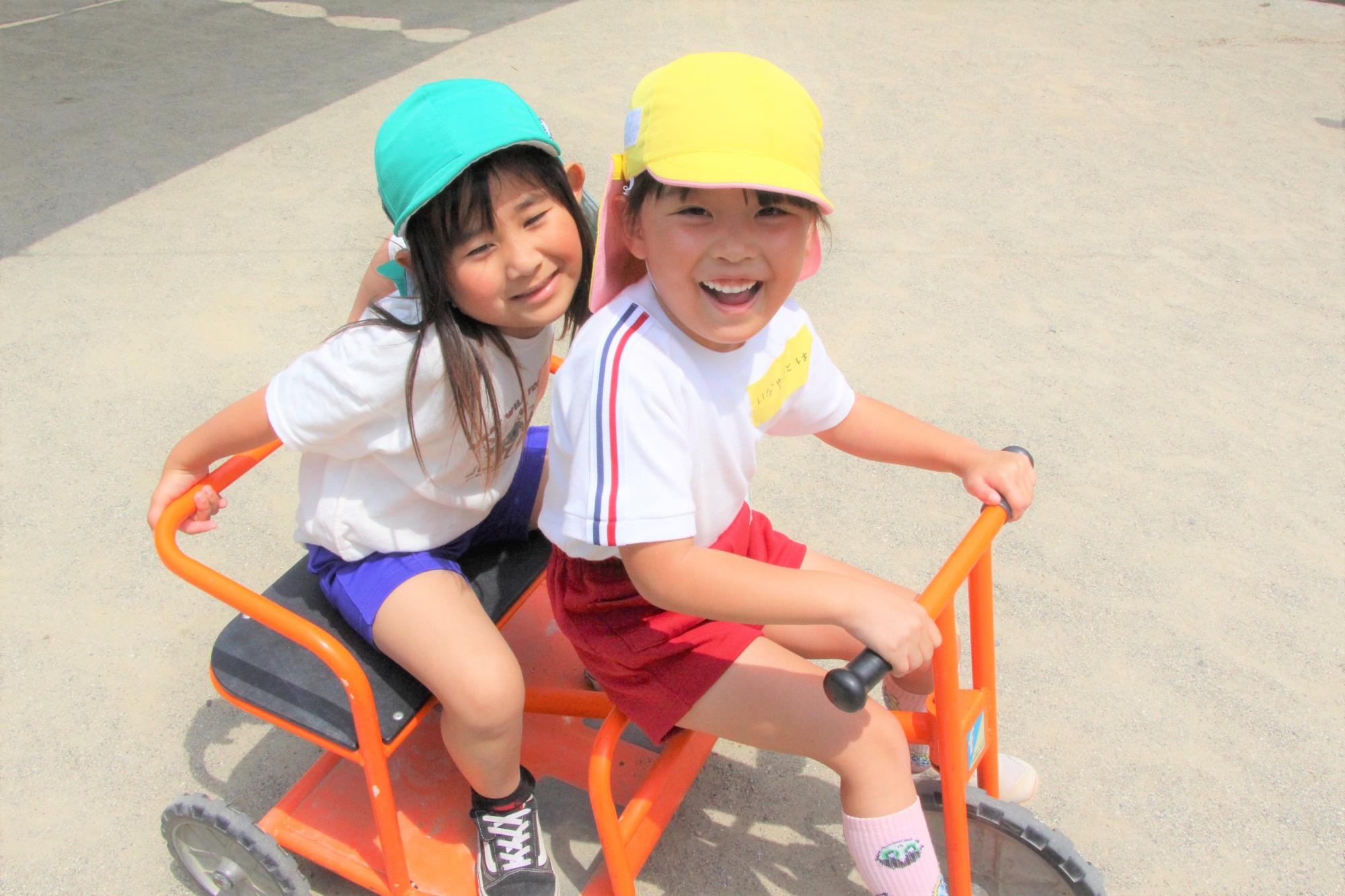 波賀幼稚園とみどり保育園の園児が三輪車に乗って笑顔の様子