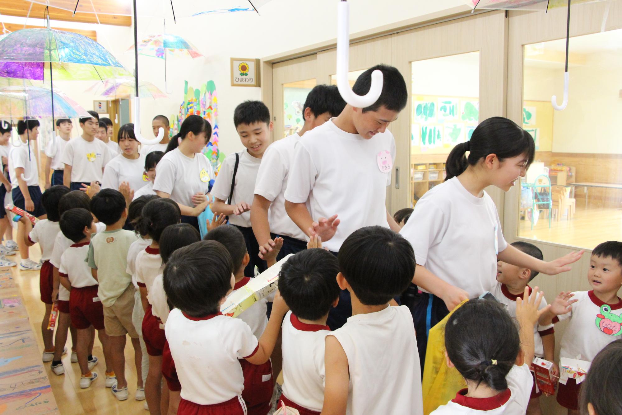 はりま一宮こども園の園児と一宮南中の生徒がハイタッチをしている様子