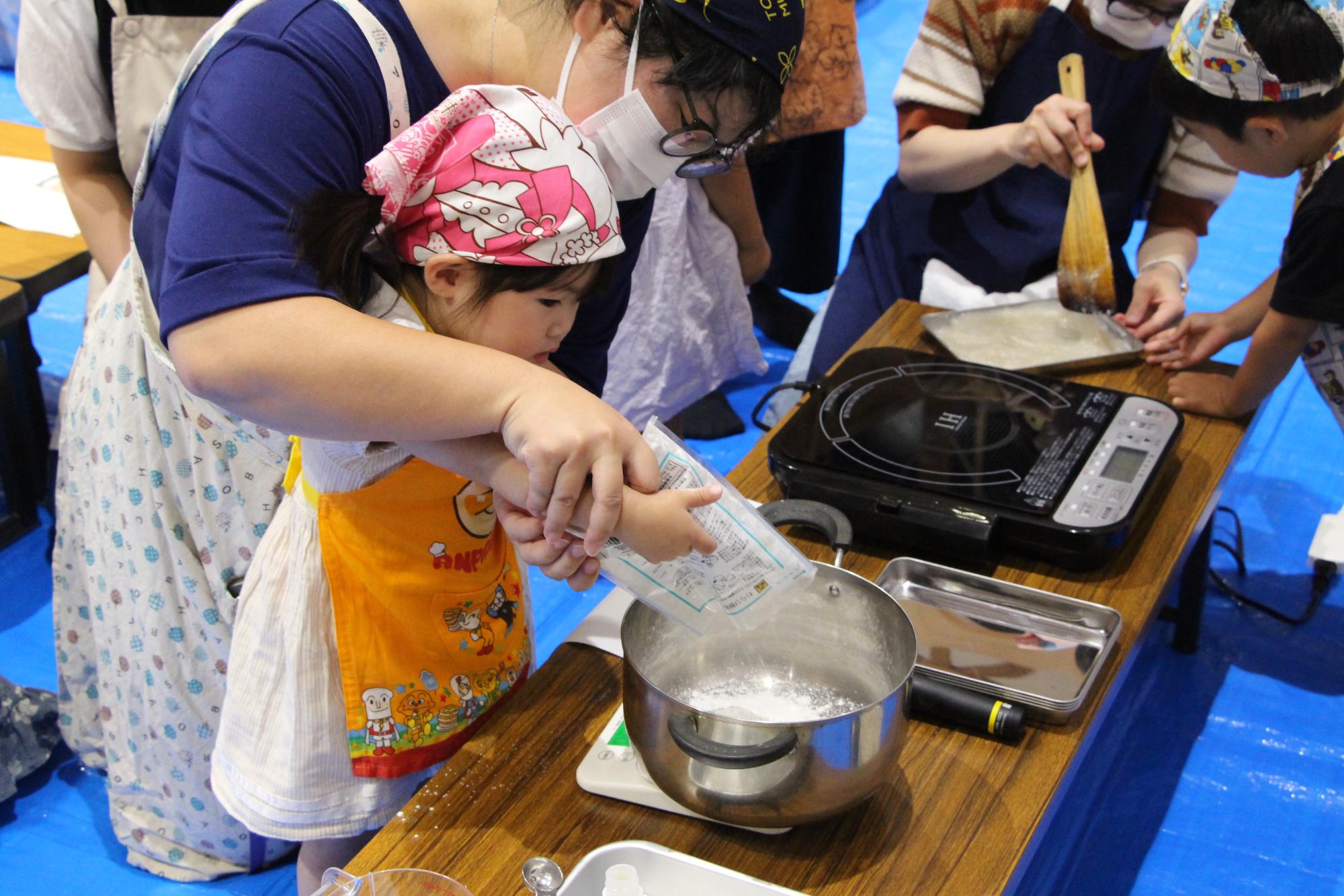親子がわらび餅粉を鍋に入れている様子