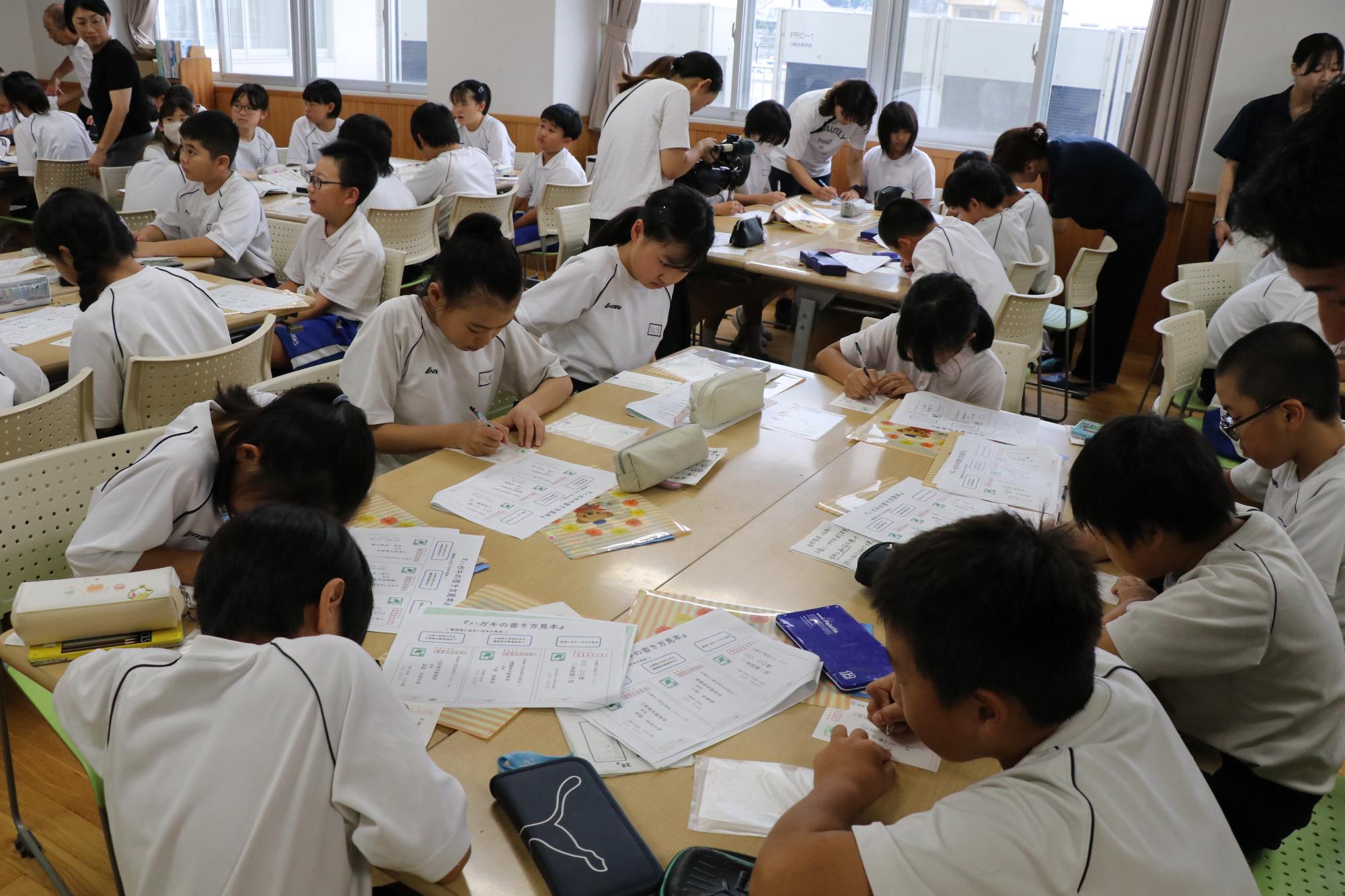 山崎小学校と山崎西小学校の5年生らが手紙を書いている様子
