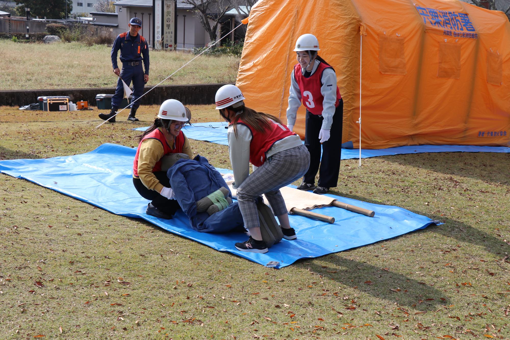 タンカにけが人（人形）を運ぶ市役所職員ら