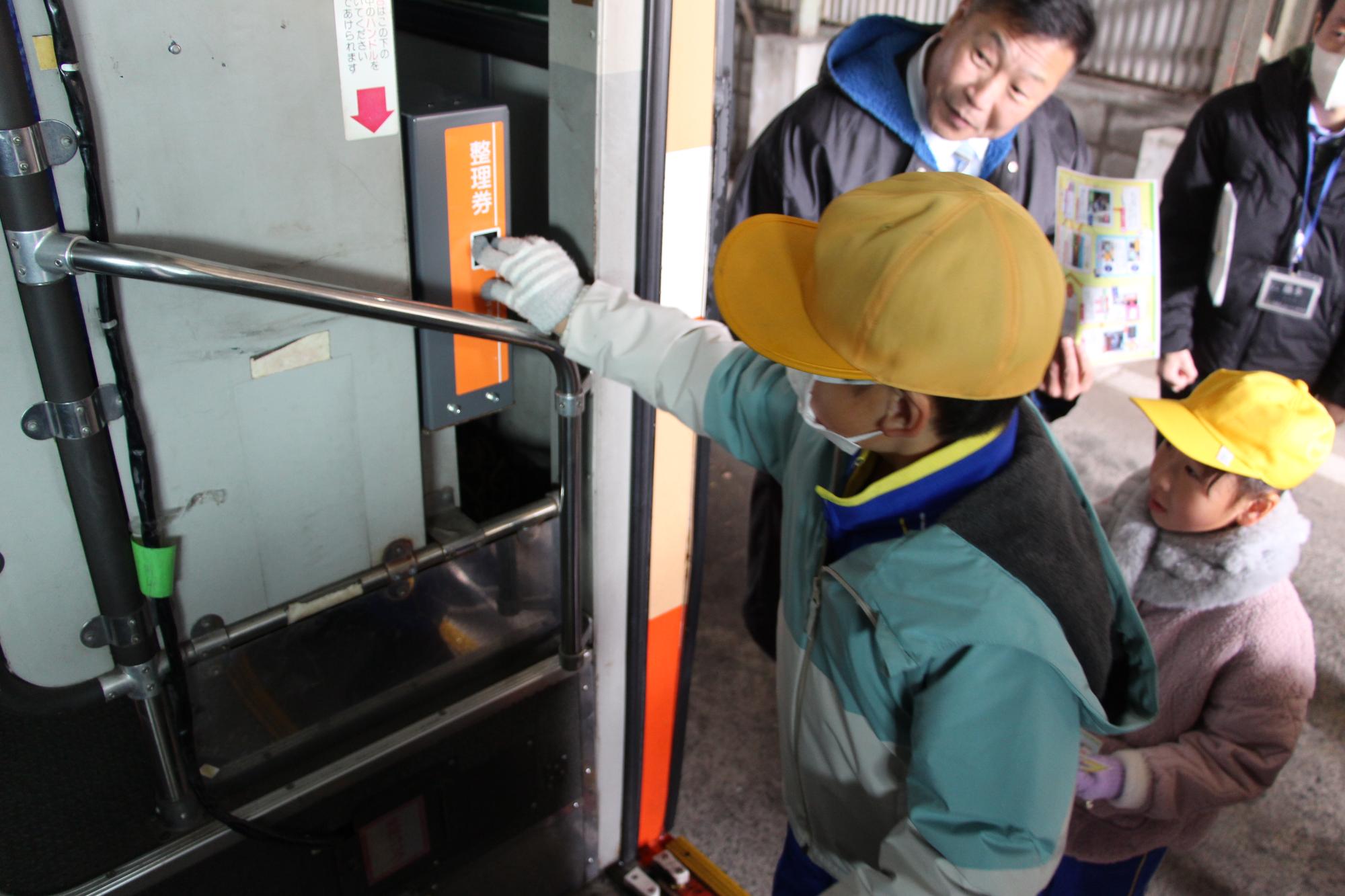 千種小学校の児童がバスの整理券を取っている様子