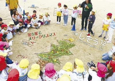 宍粟わかばとかしわの保育所と聖誠保育園の園児たちが夢公園で公園内の落ち葉などを使ってクリスマスツリーを作った写真