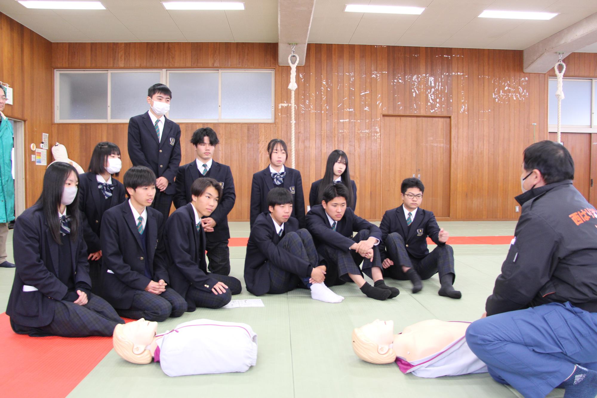 心臓マッサージのやり方を教わる山高生