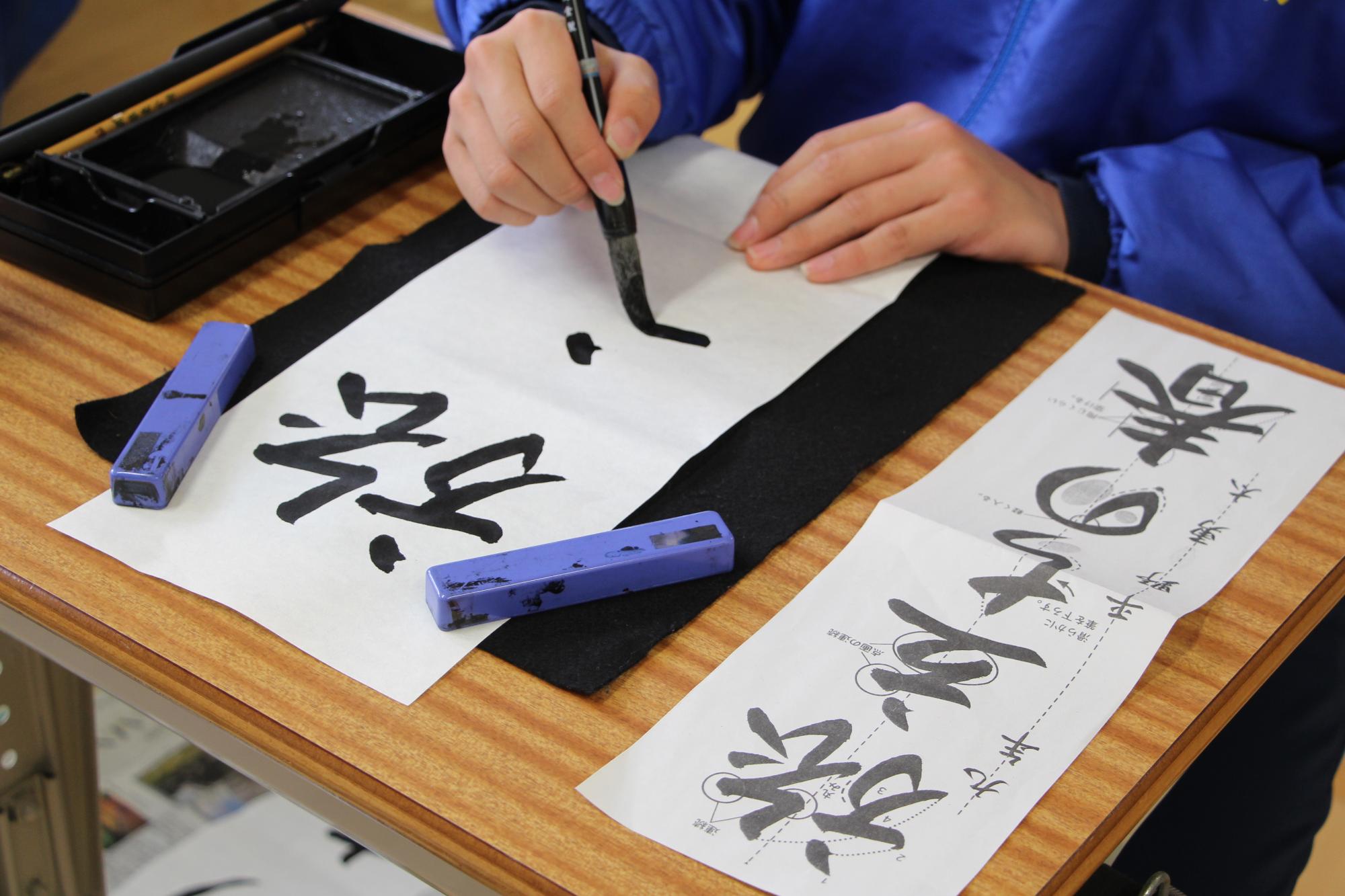 書道で「旅立ちの春」を書いている様子